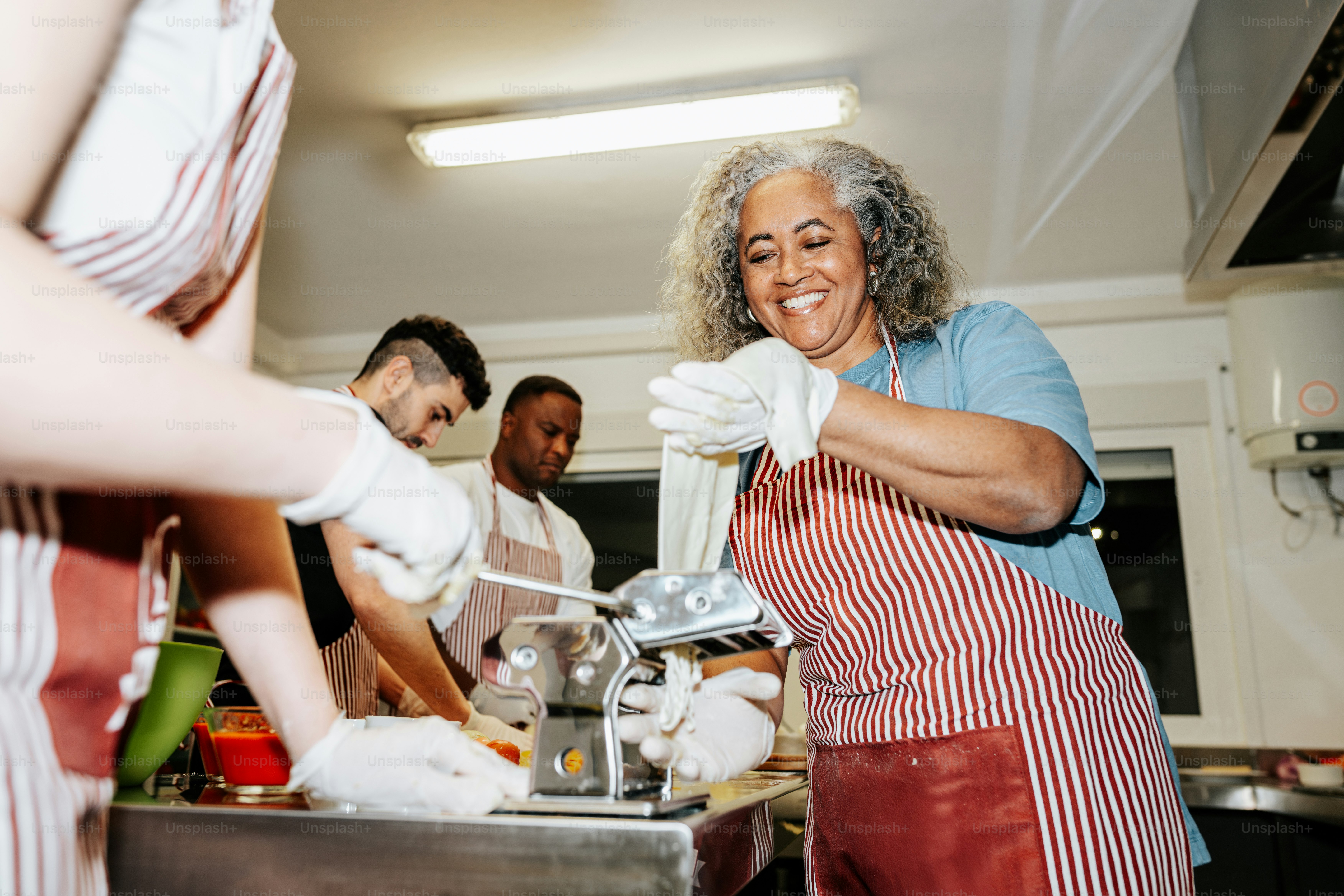 A group of people in a kitchen preparing food photo – Food Image on ...