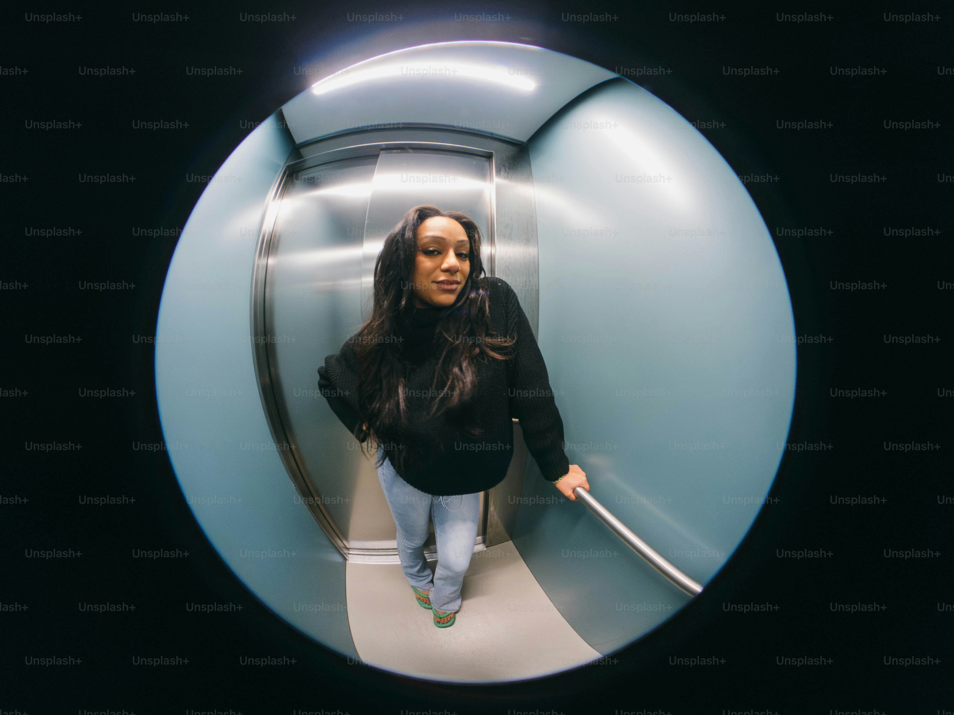 円形の鏡に女性が立っています