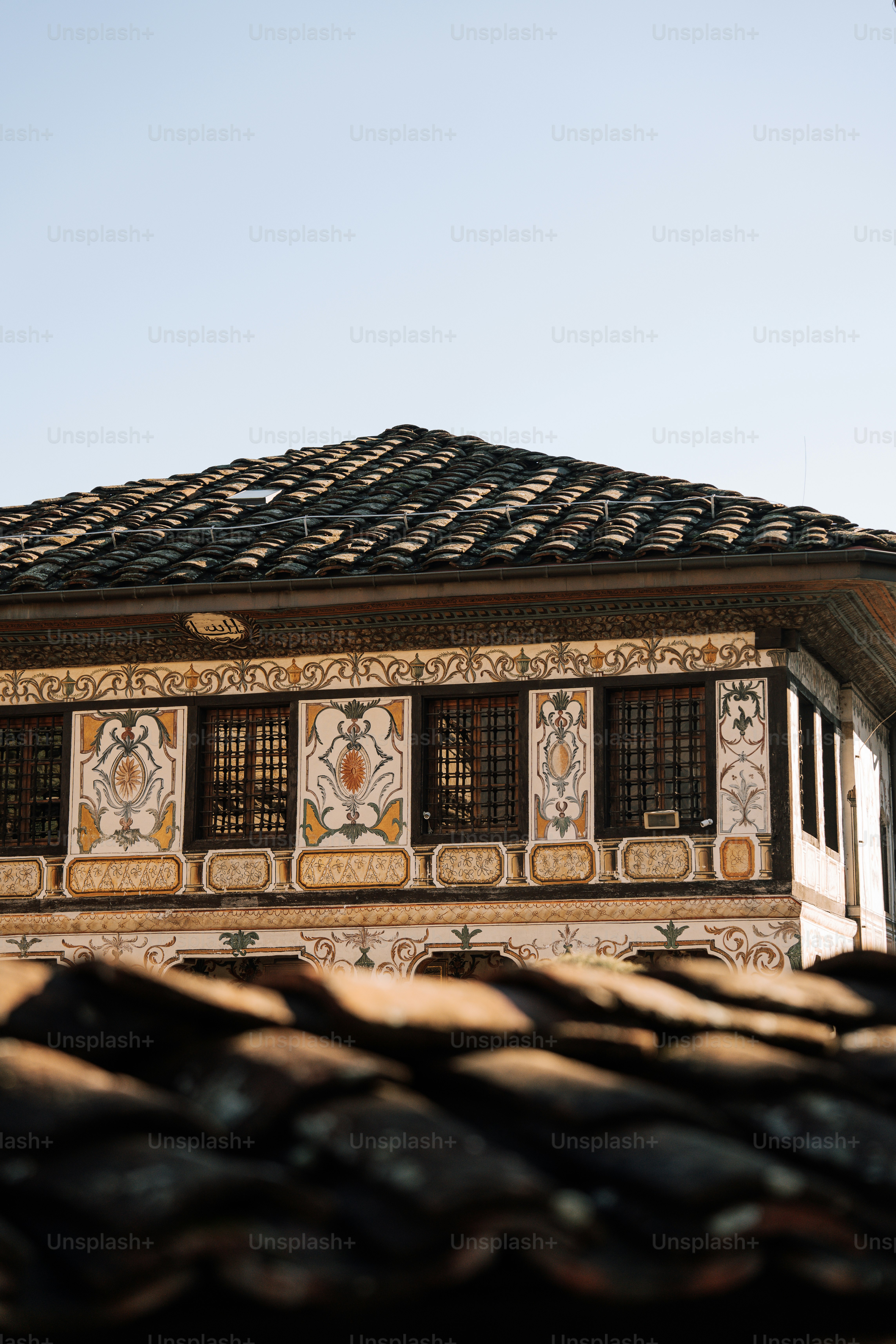 A building with a tiled roof and a bird flying by