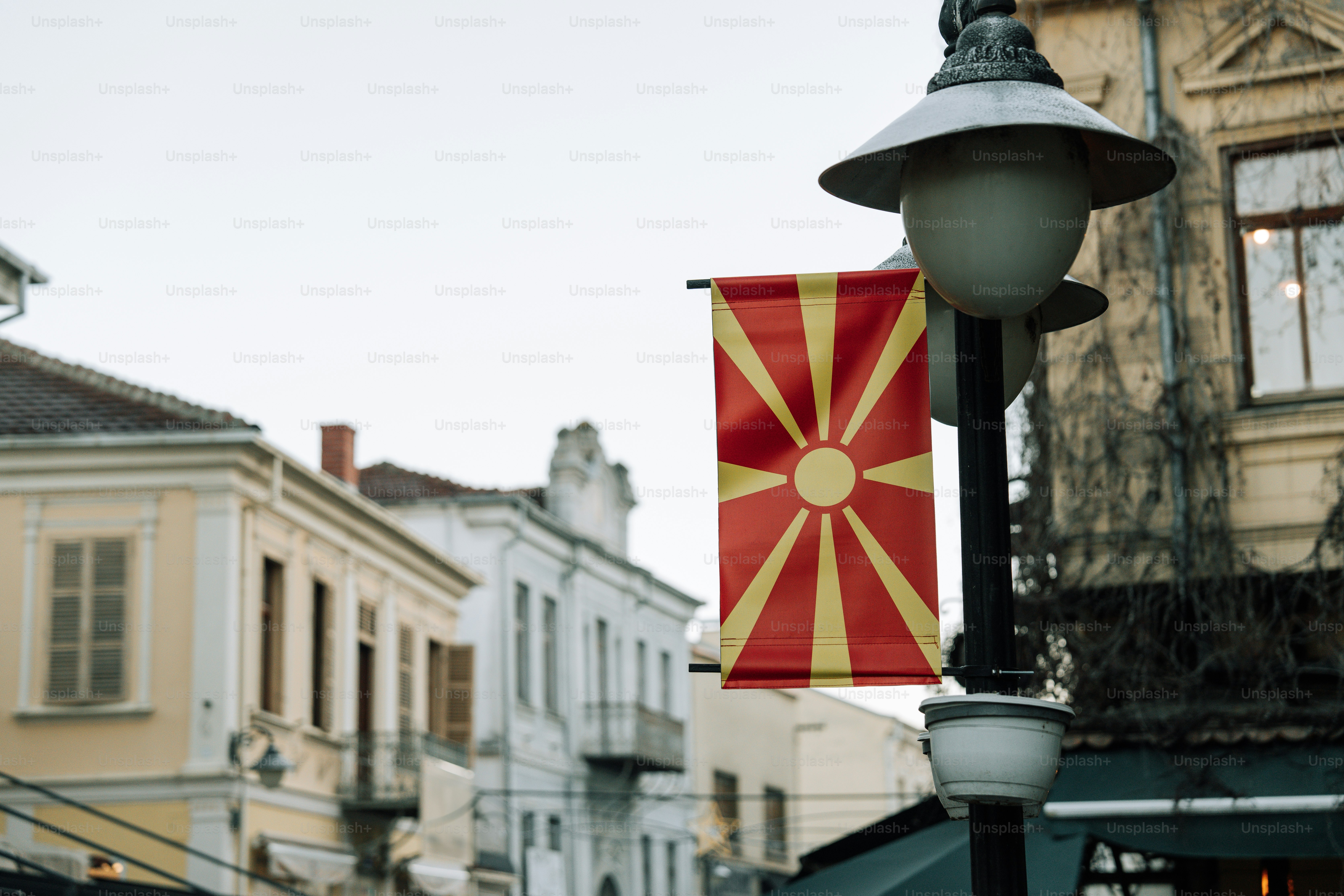 A street light with a flag hanging from it's side