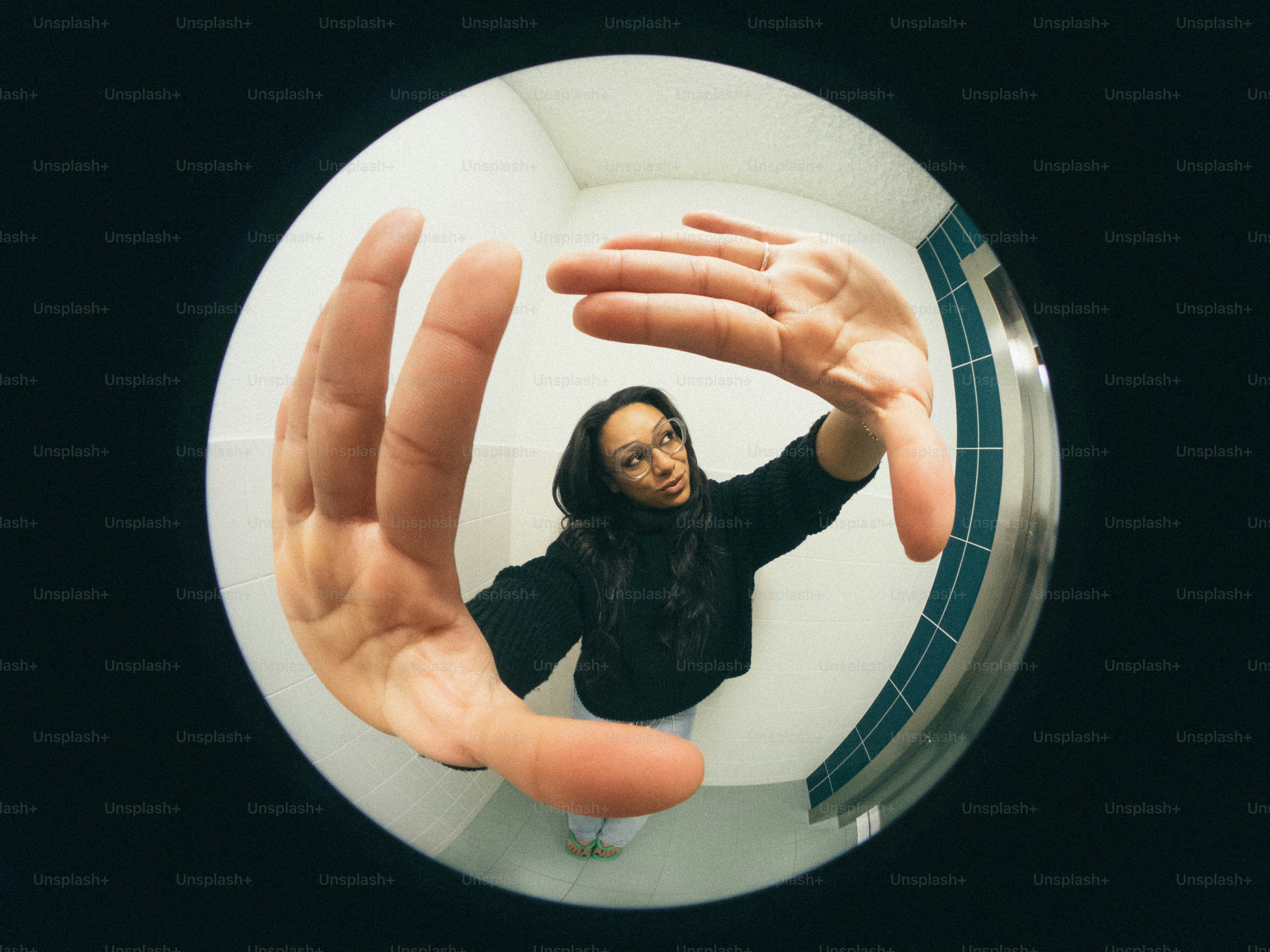 A woman standing in front of a mirror with her hands in the air
