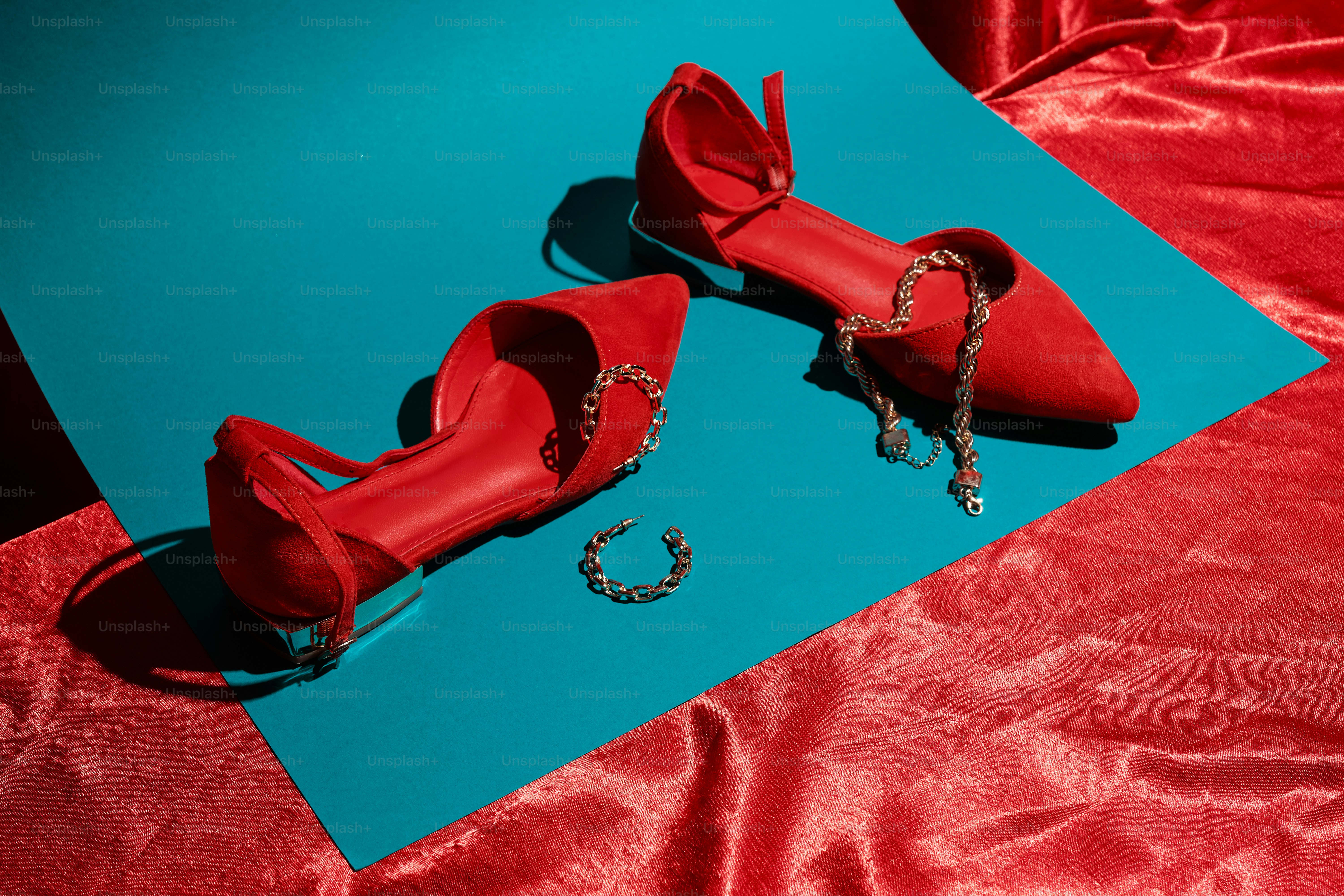 Un paio di scarpe rosse sedute sopra un lenzuolo blu