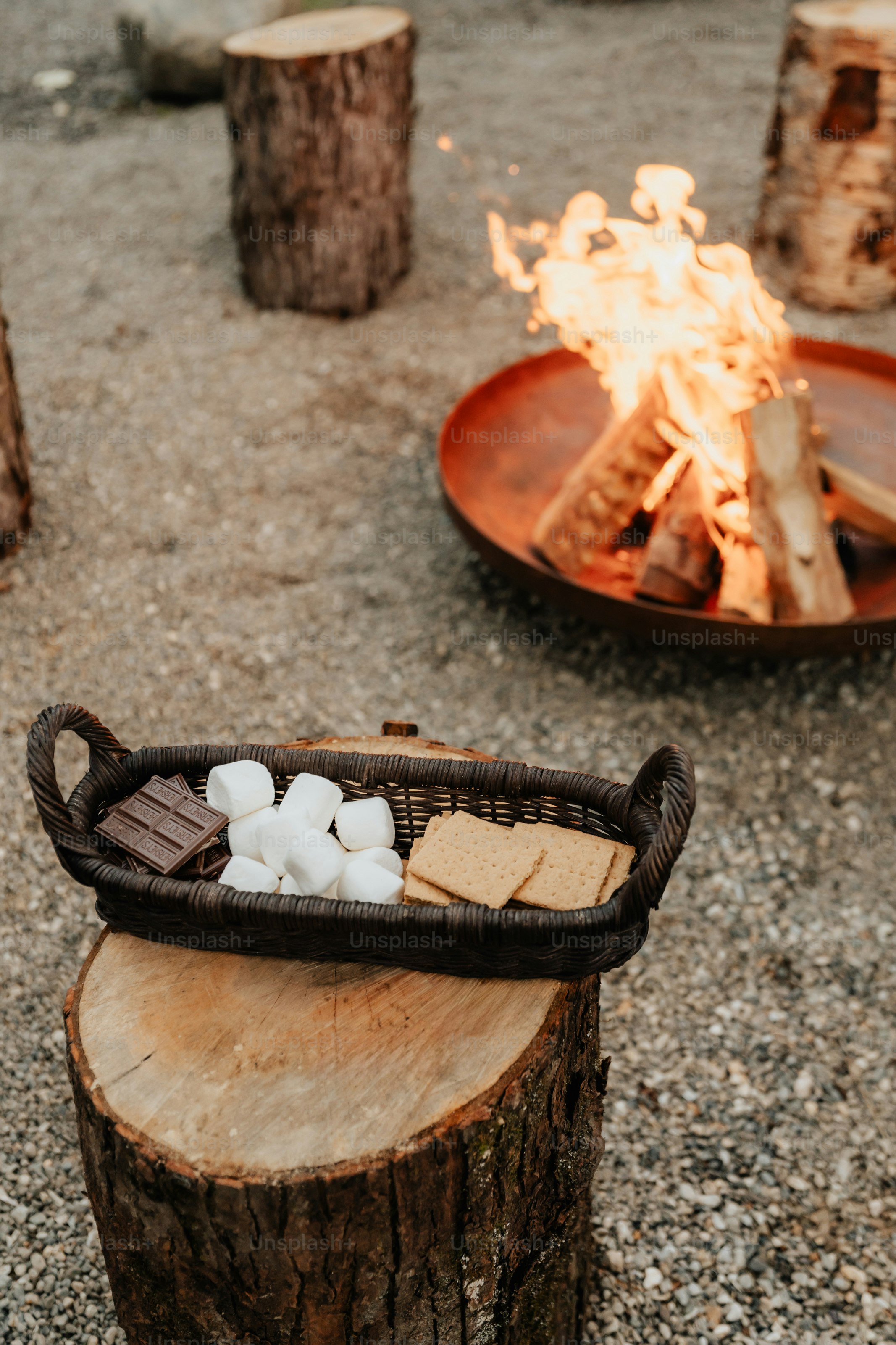 A basket filled with marshmallows sitting on top of a tree stump
