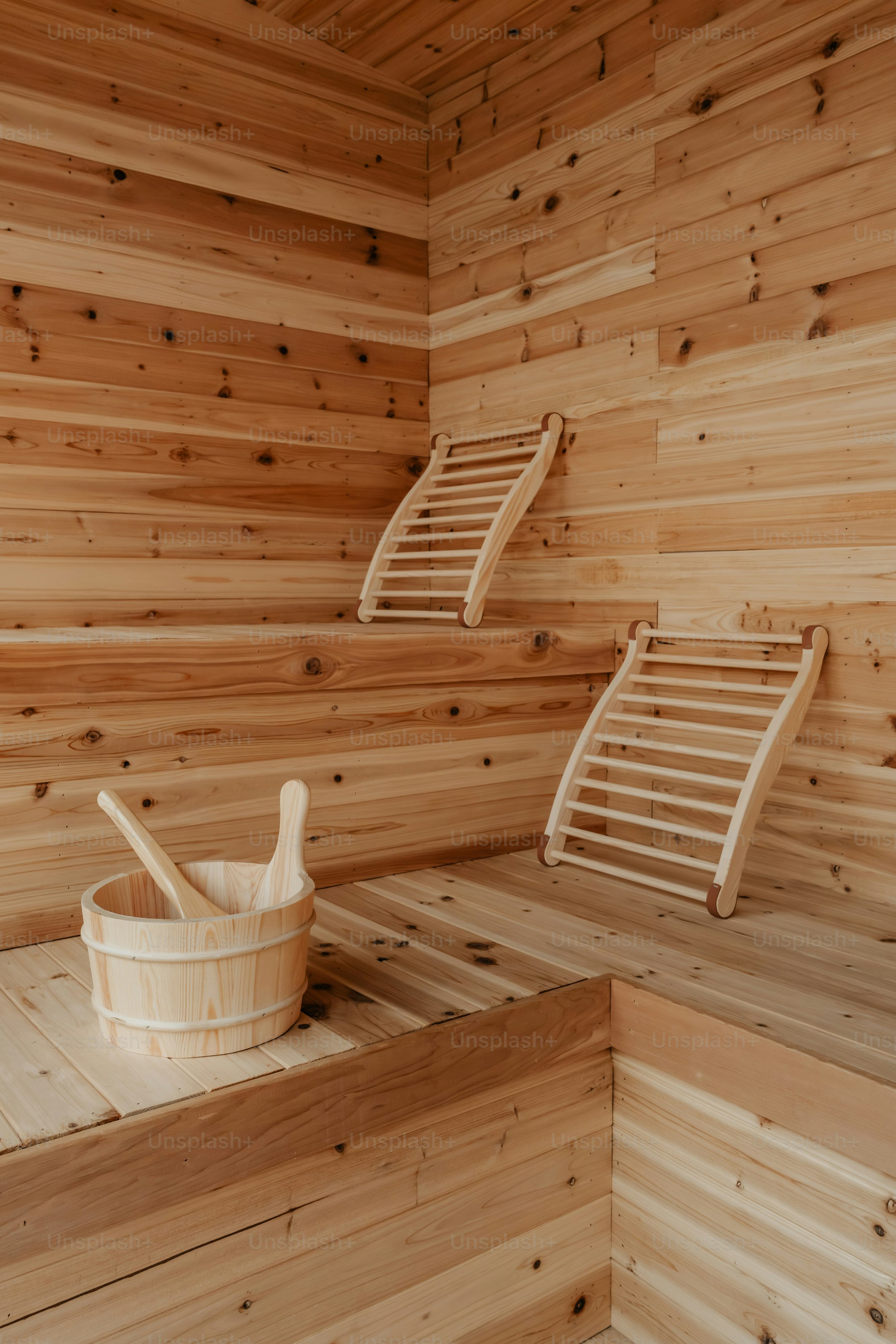 Eine Holzsauna mit zwei Stühlen und einem Eimer