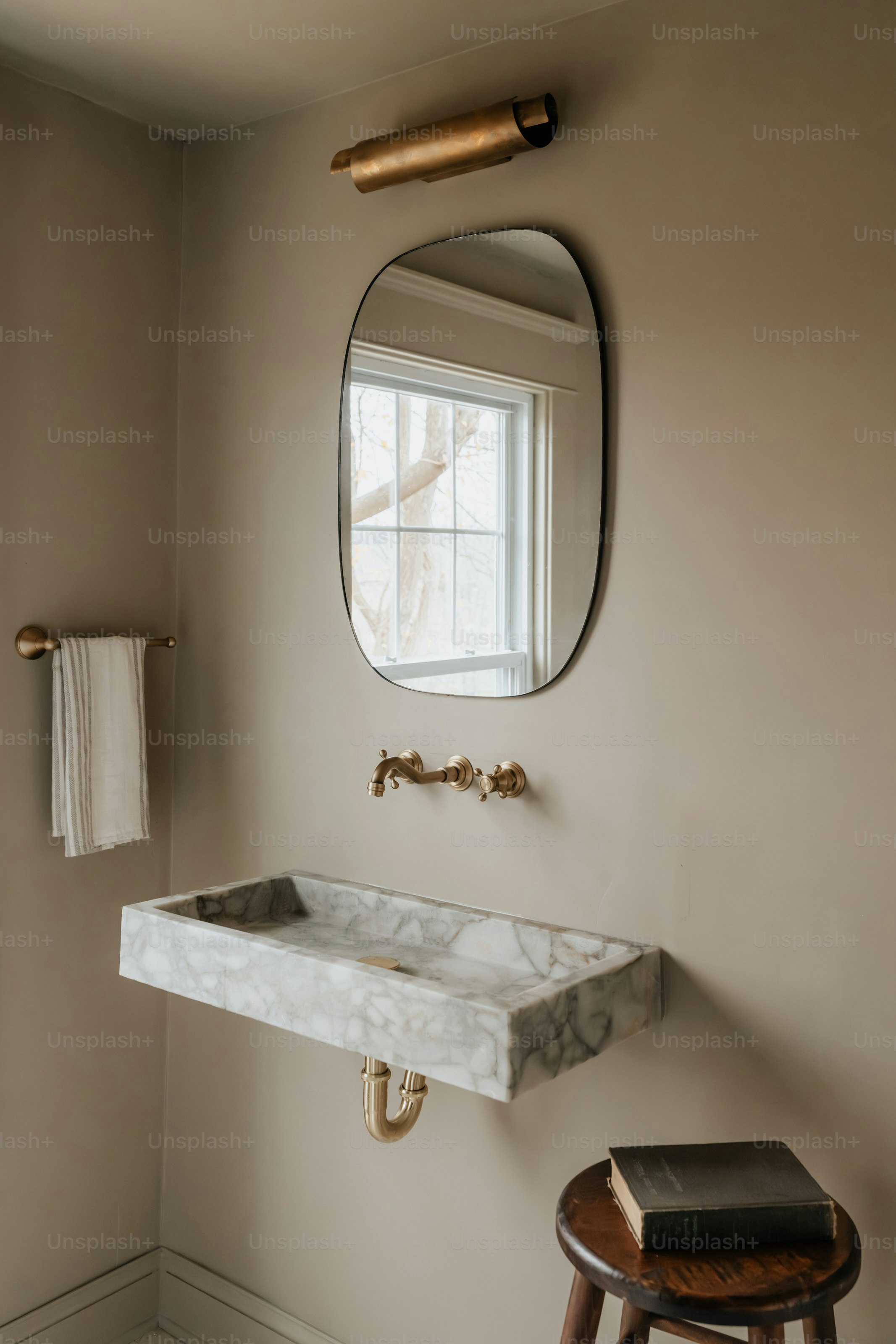 A bathroom with a sink, mirror and stool