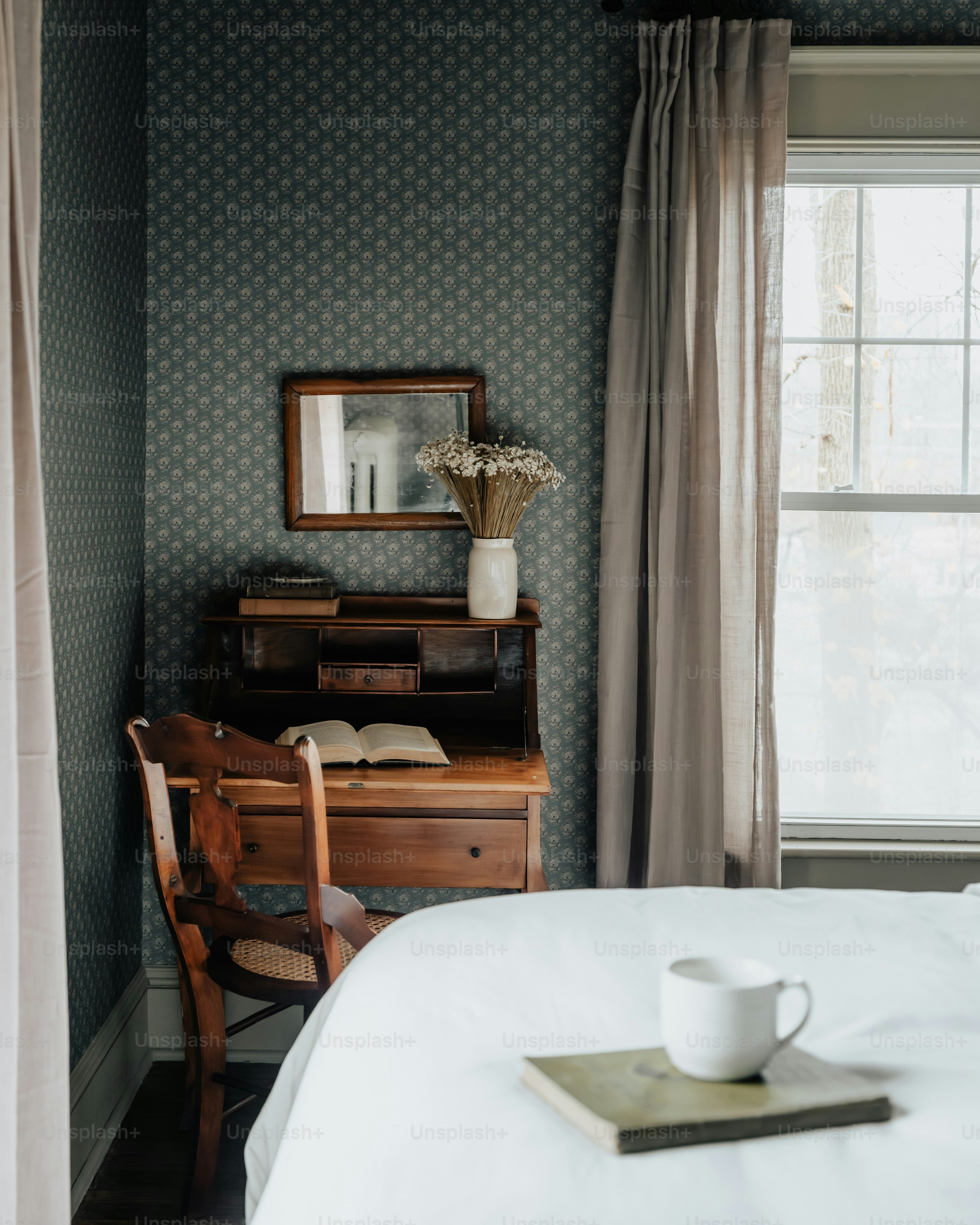 Um quarto com uma cama branca e uma secretária