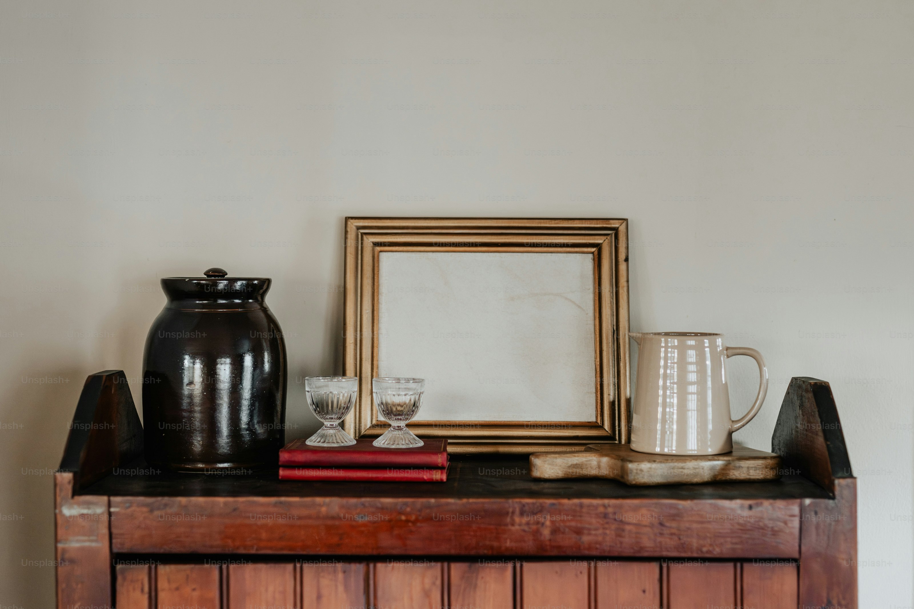 Um armário de madeira com um espelho e um vaso em cima dele