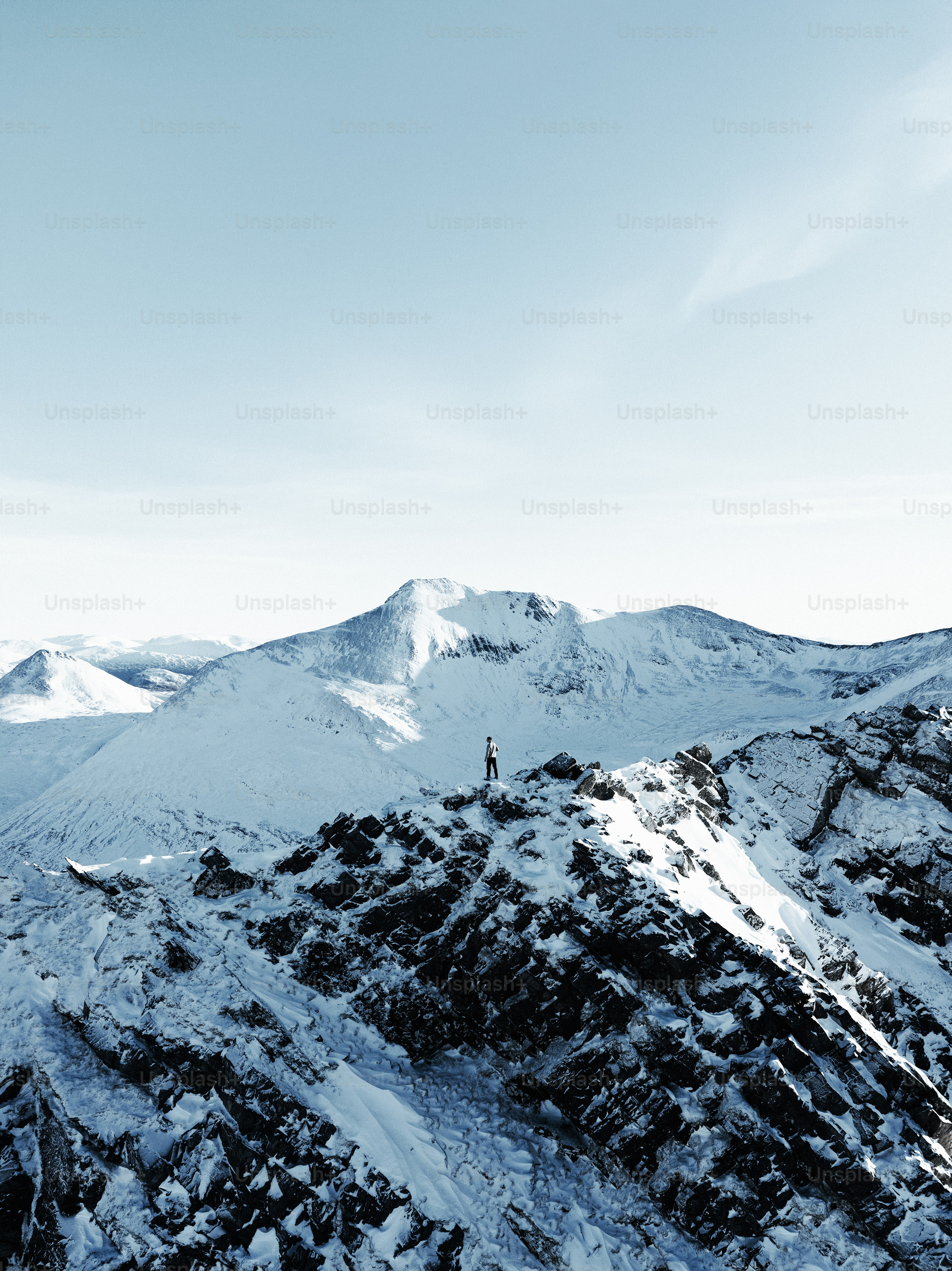 Une personne sur un snowboard dans les airs au-dessus d’une montagne enneigée