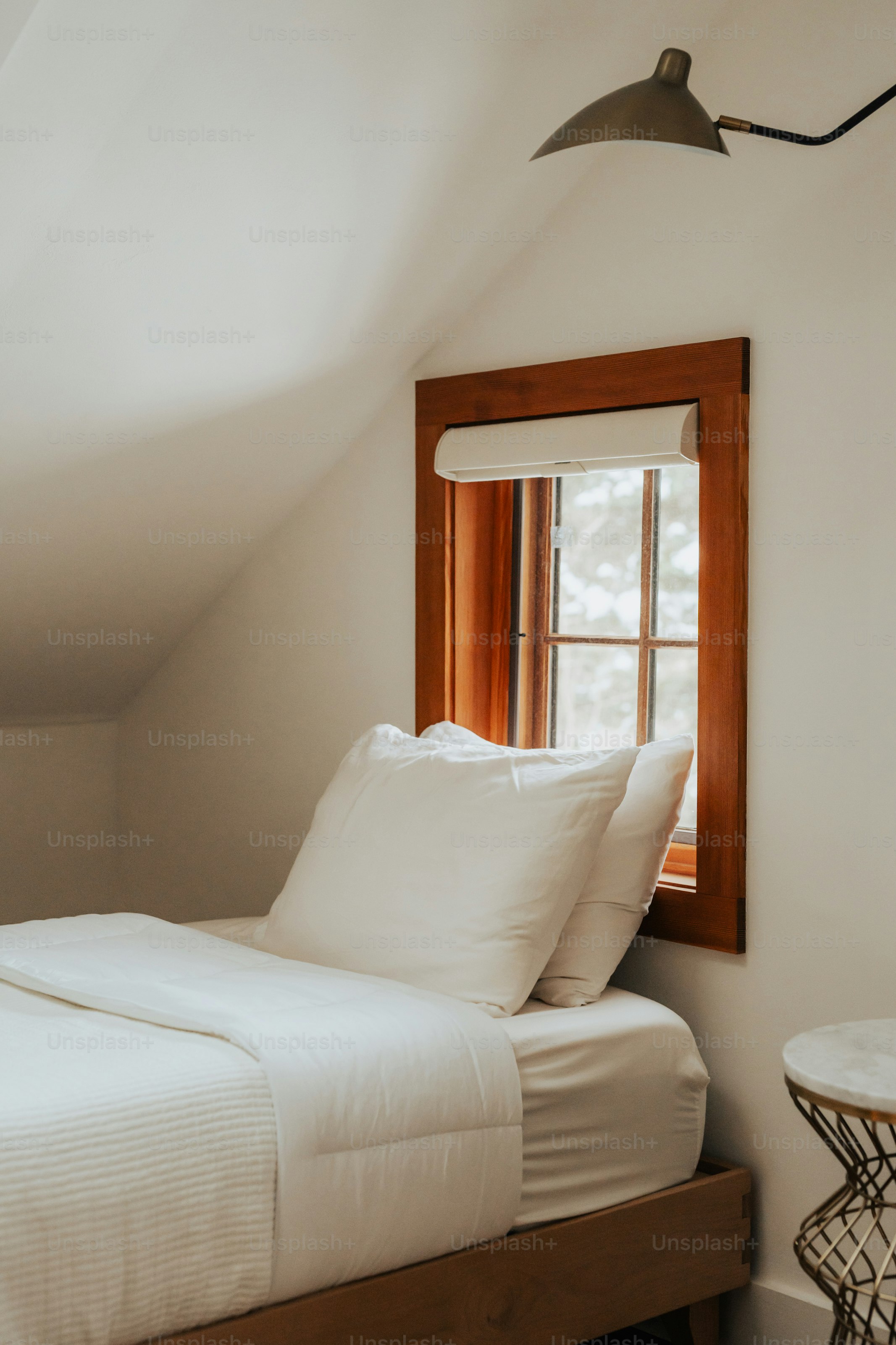 A bed sitting under a window in a bedroom