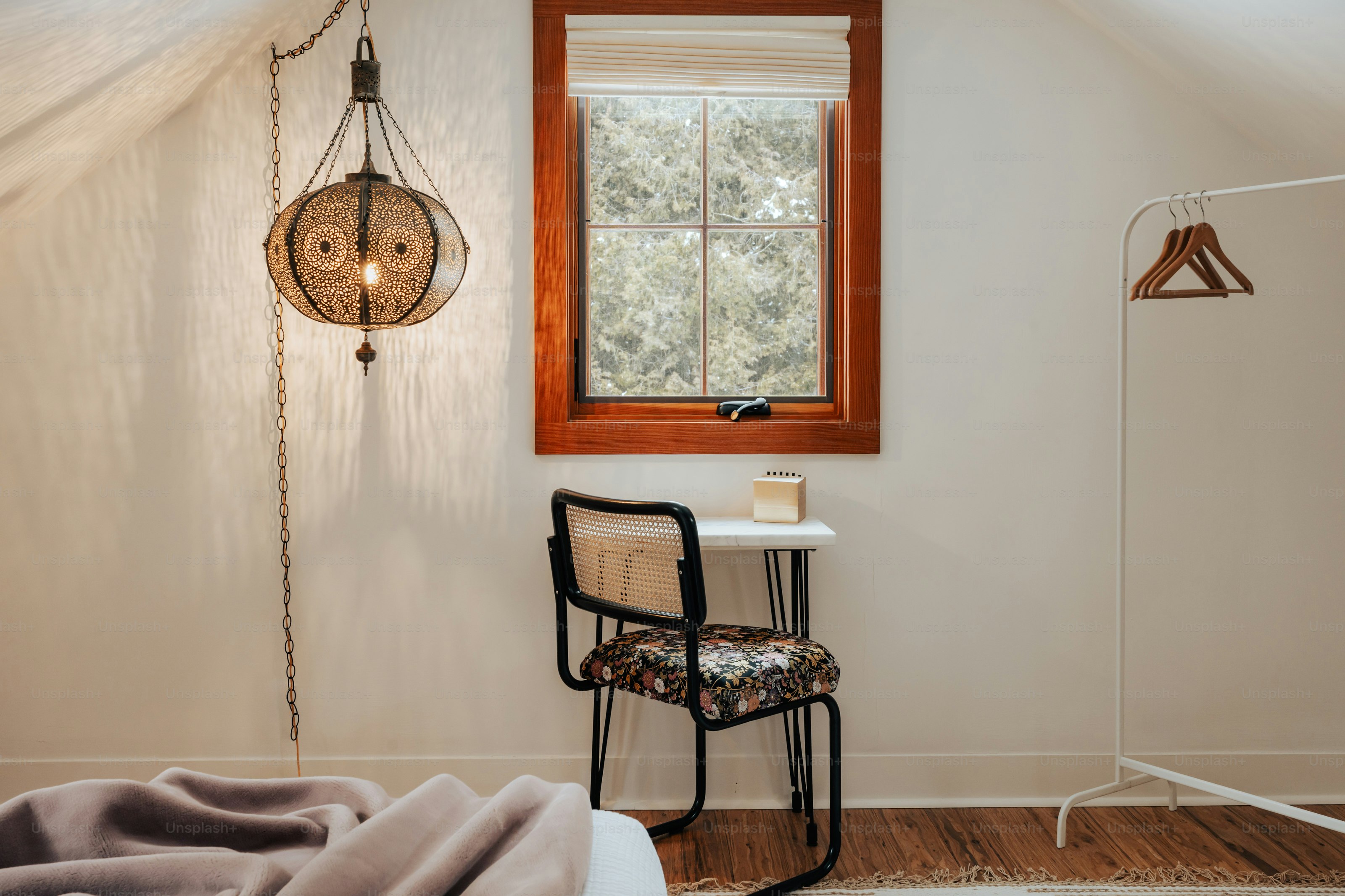 A bedroom with a bed, chair and a window