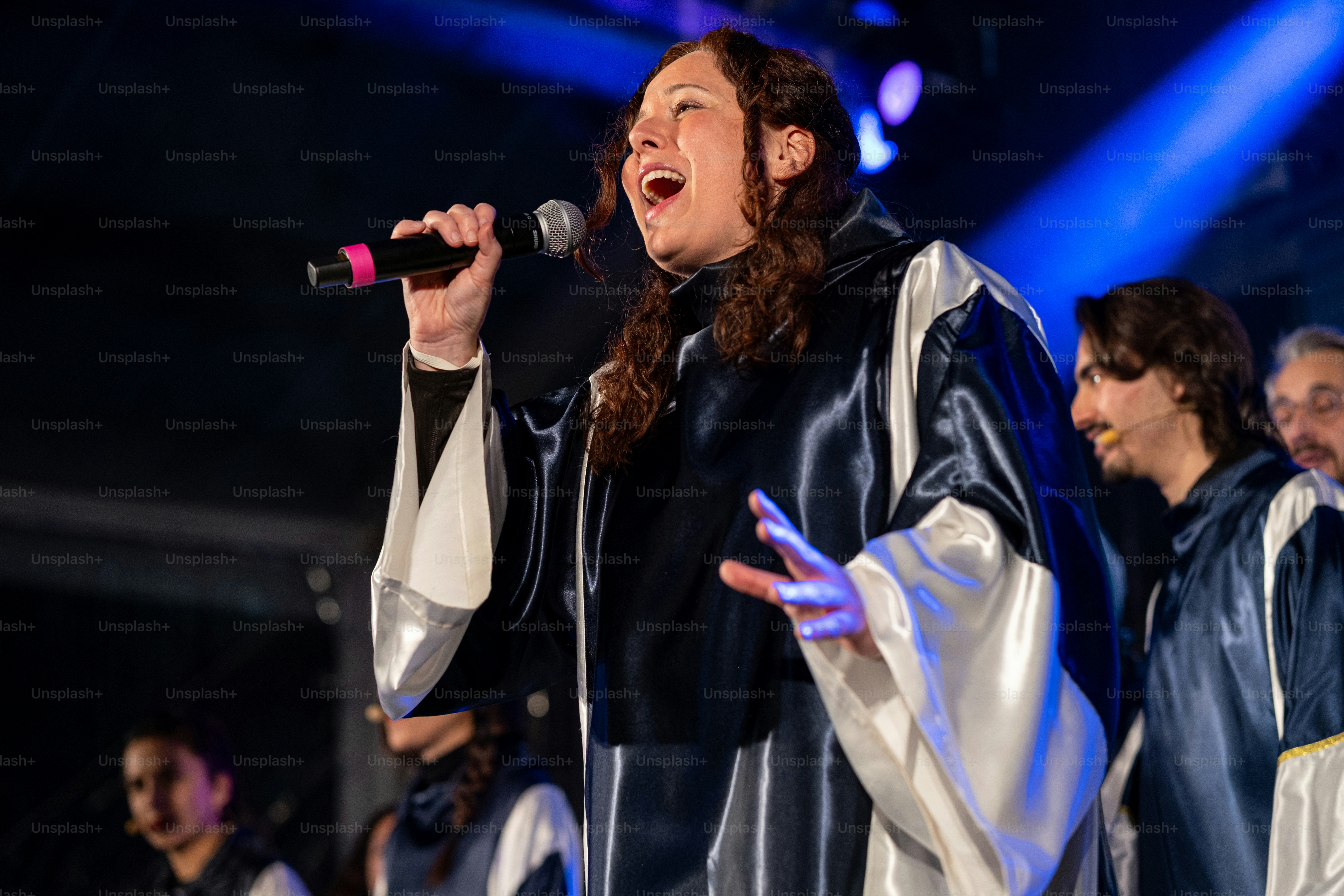 A woman singing into a microphone on stage