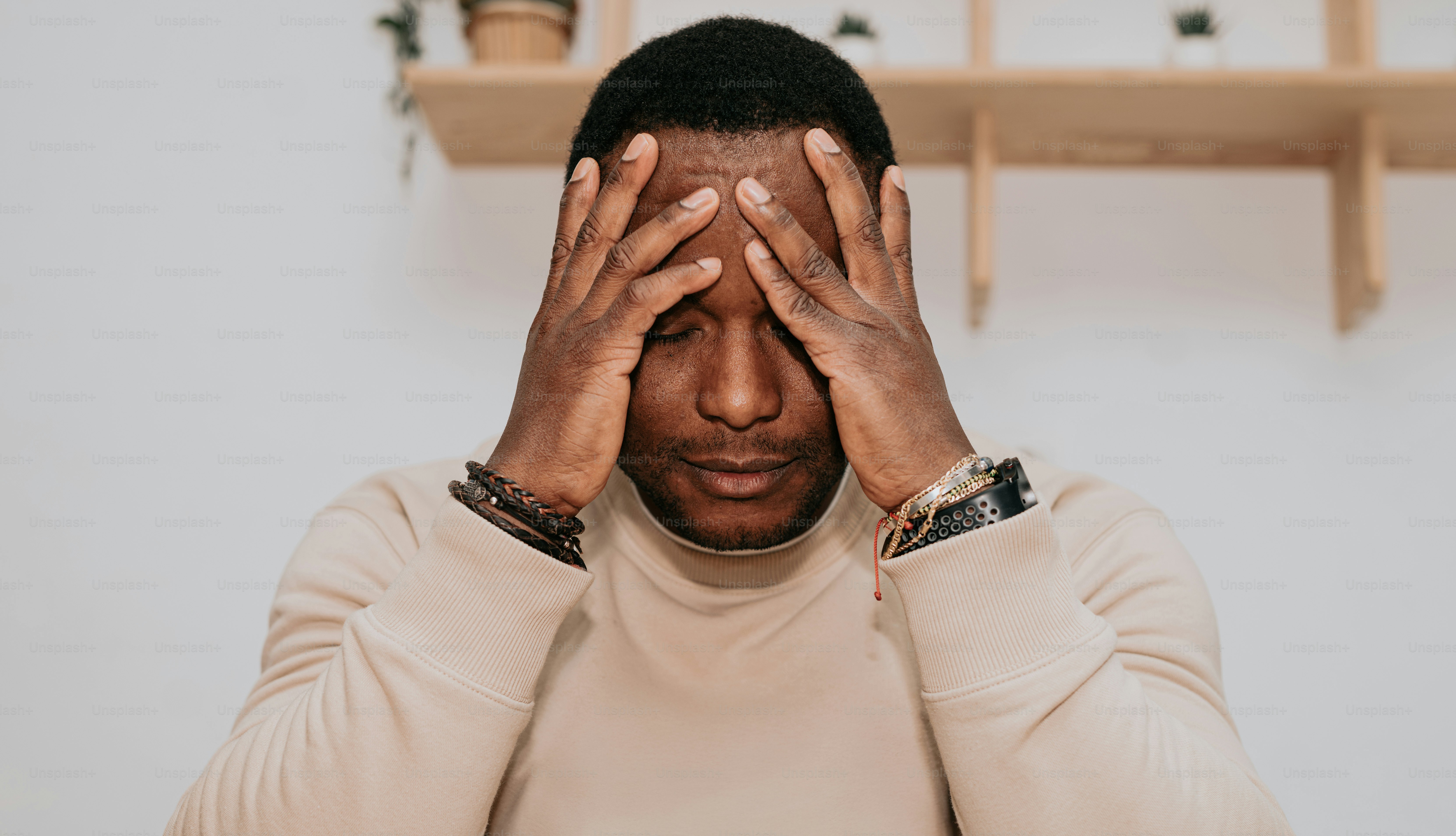 Un hombre tapándose los ojos con las manos