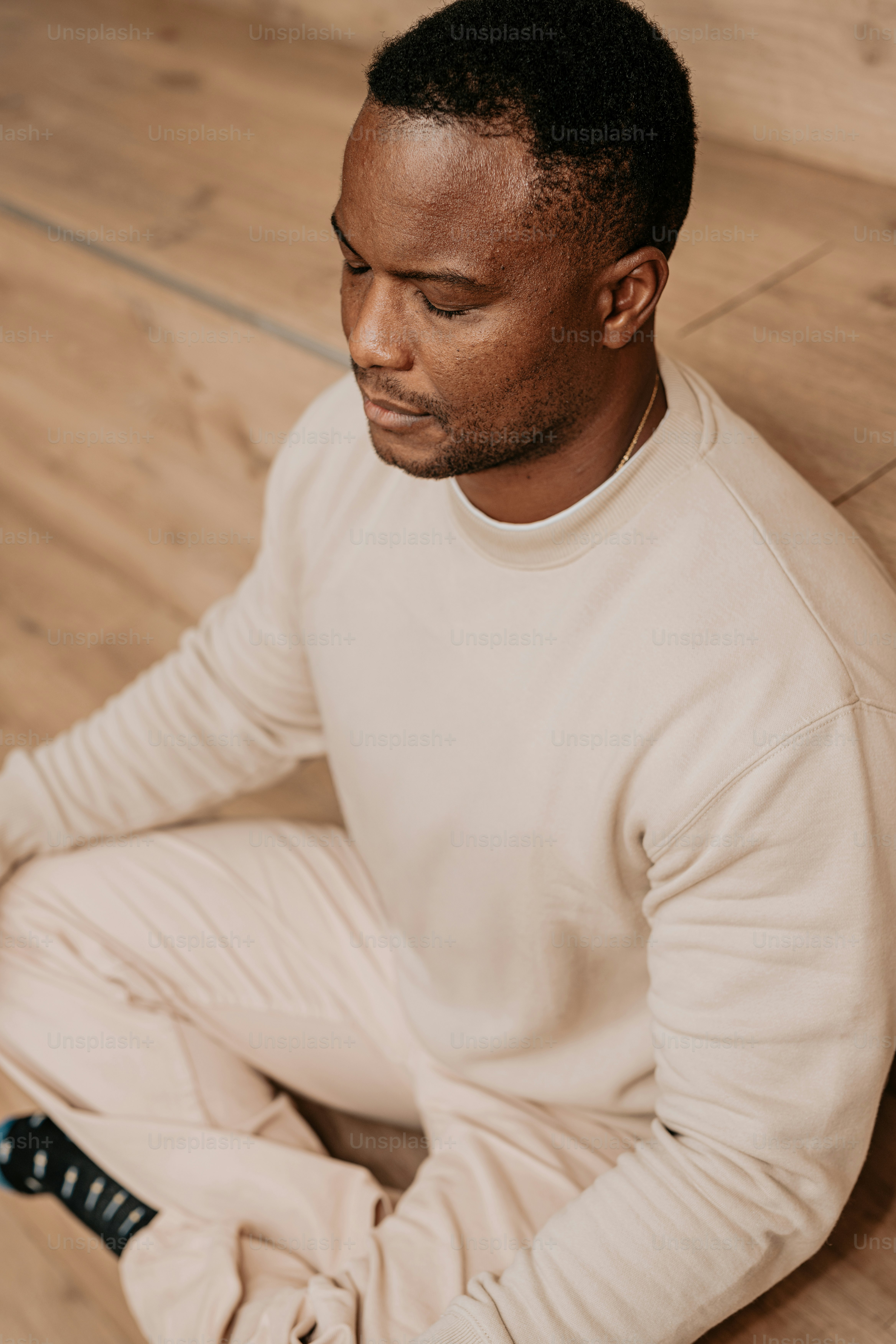 A man sitting on the floor with his eyes closed