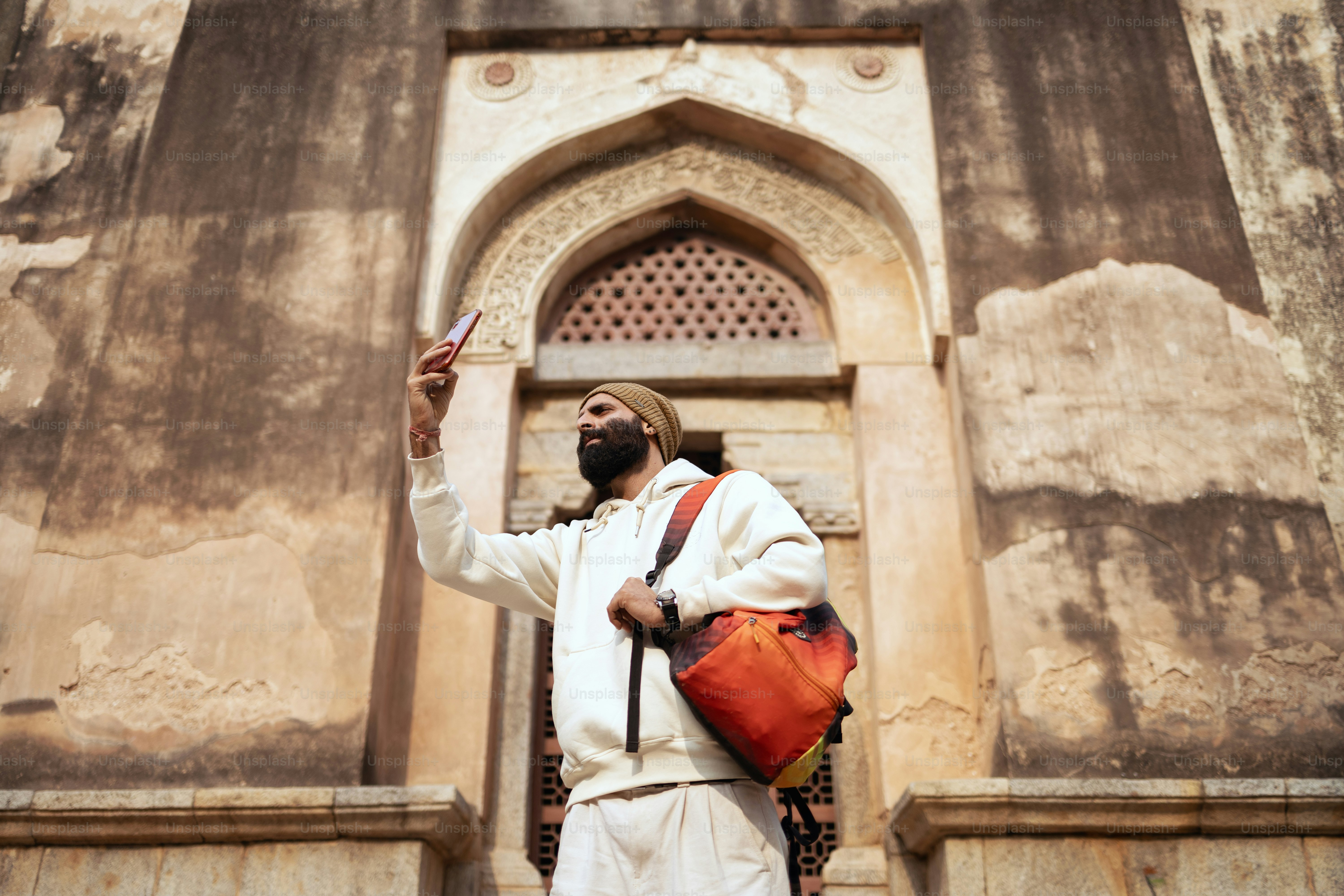 Un hombre de pie frente a un edificio alto