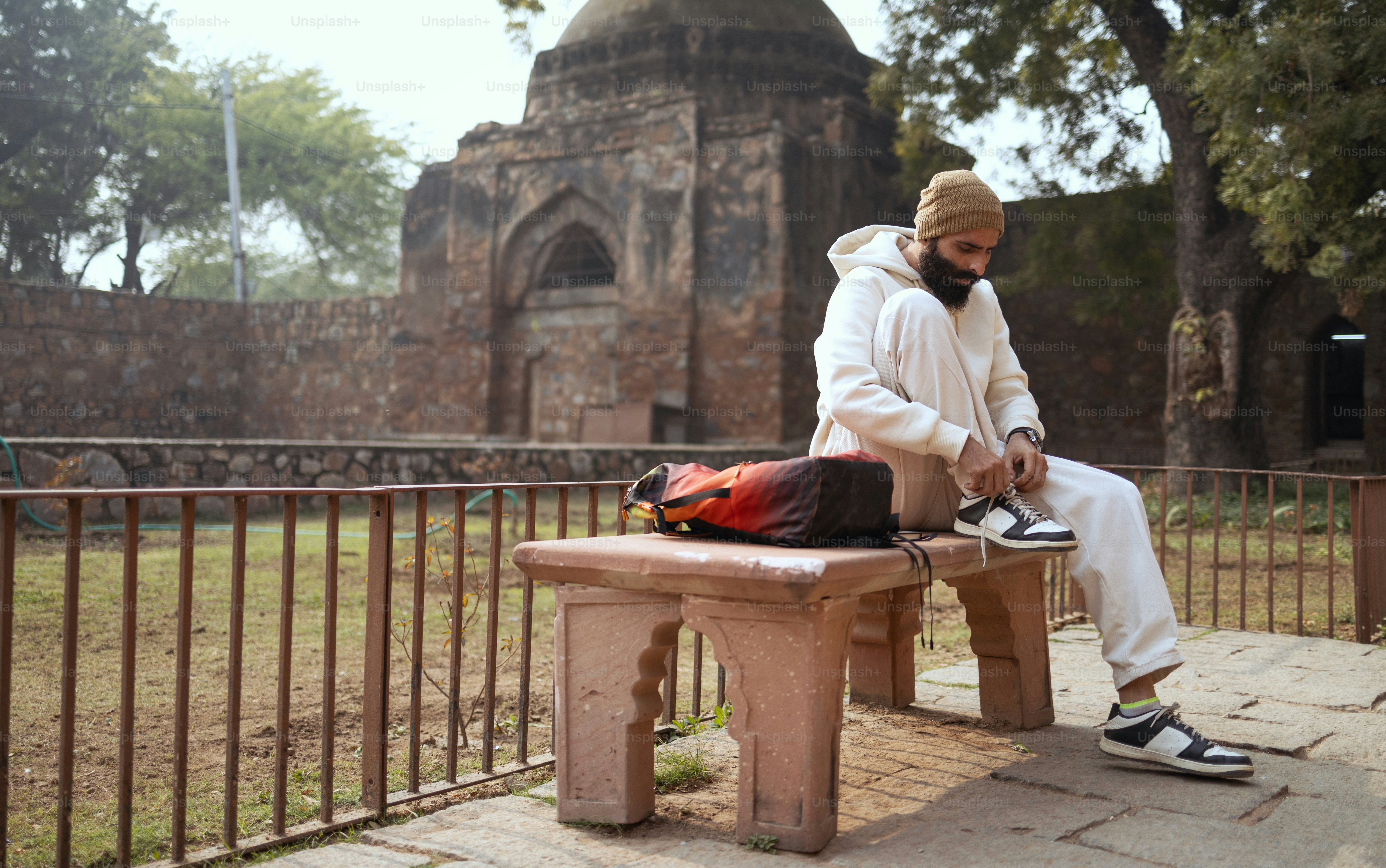 A man sitting on a bench in front of an old building
