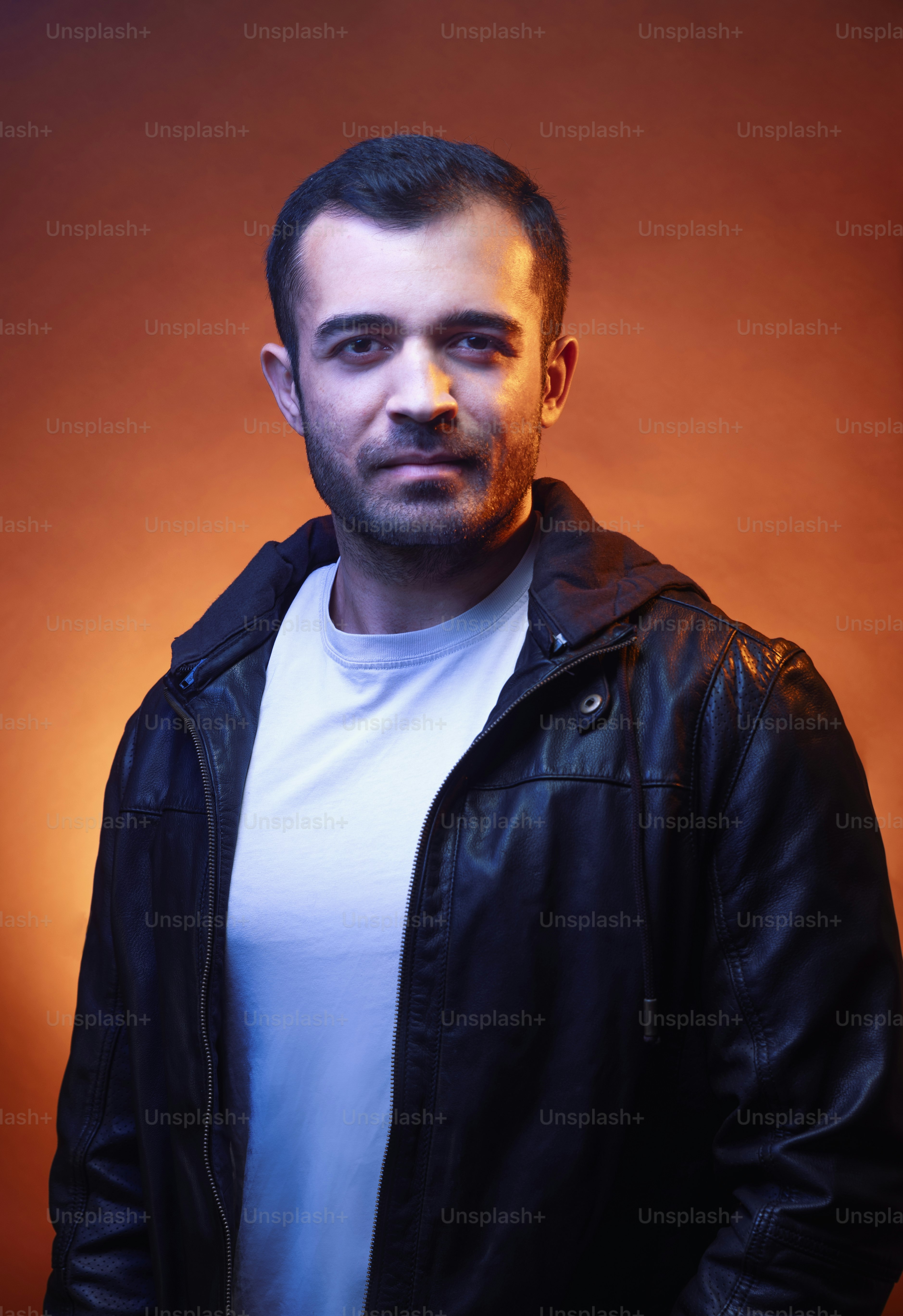 A man in a leather jacket posing for a picture