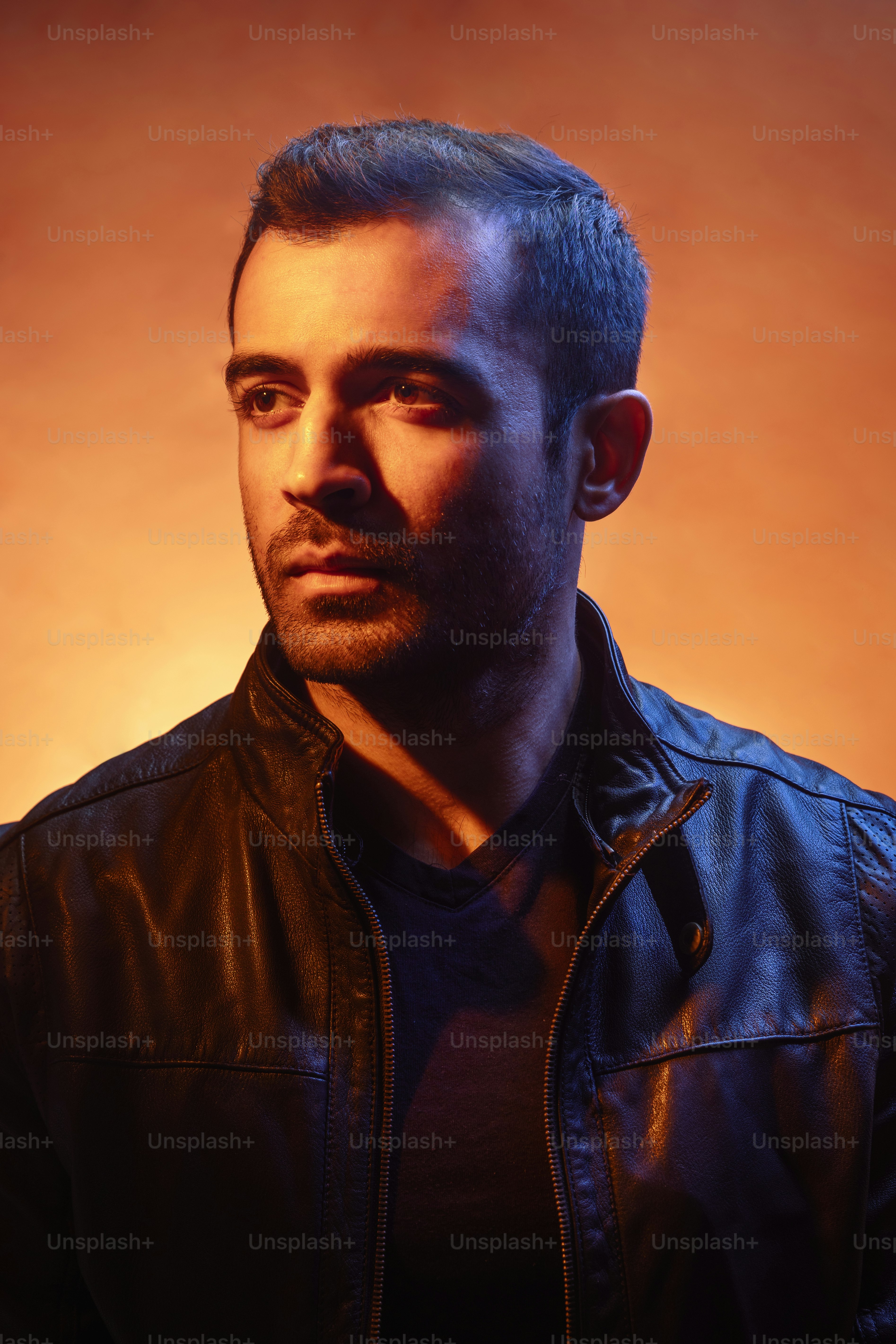 A man in a black leather jacket looking at the camera