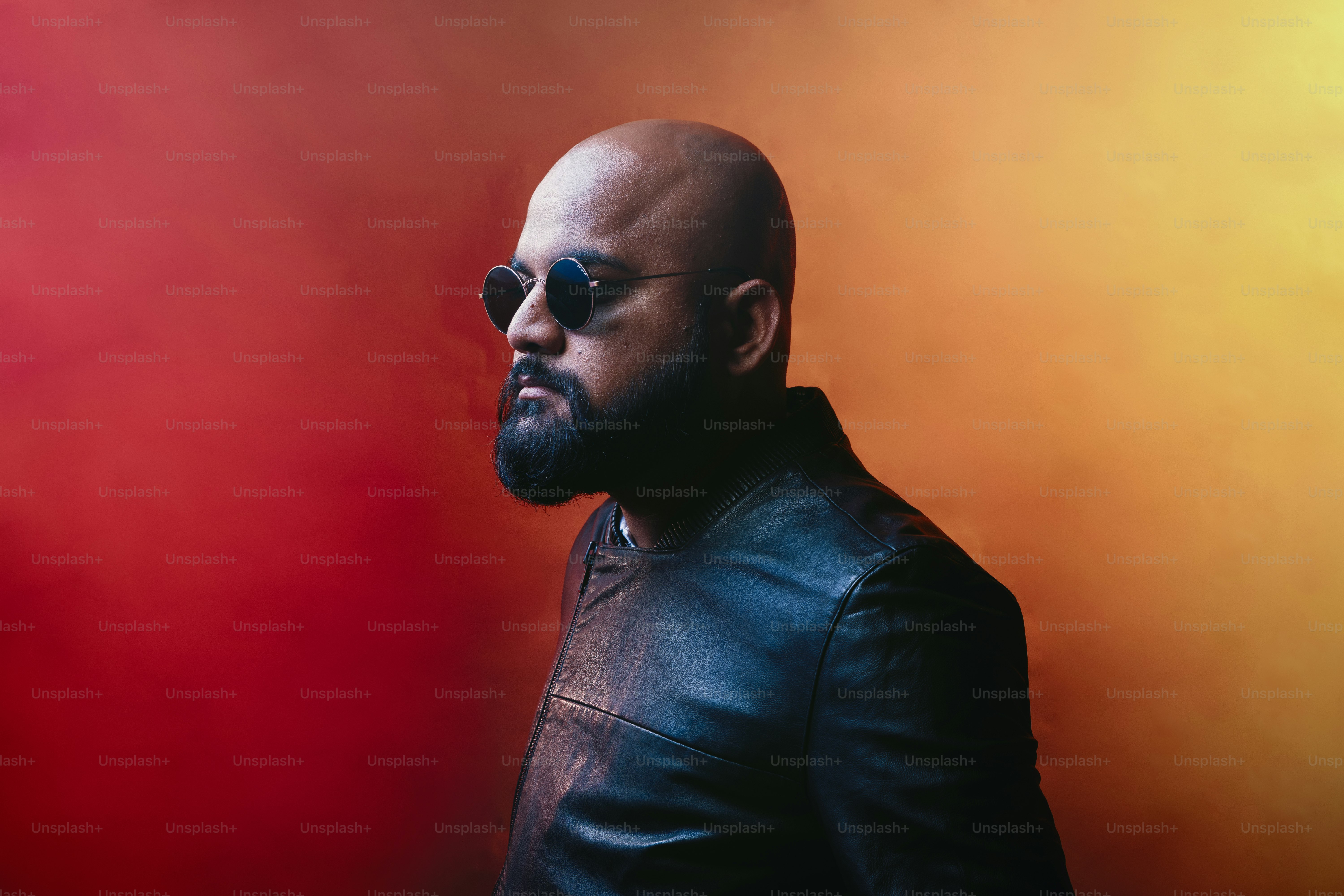 A bald man in a leather jacket and sunglasses