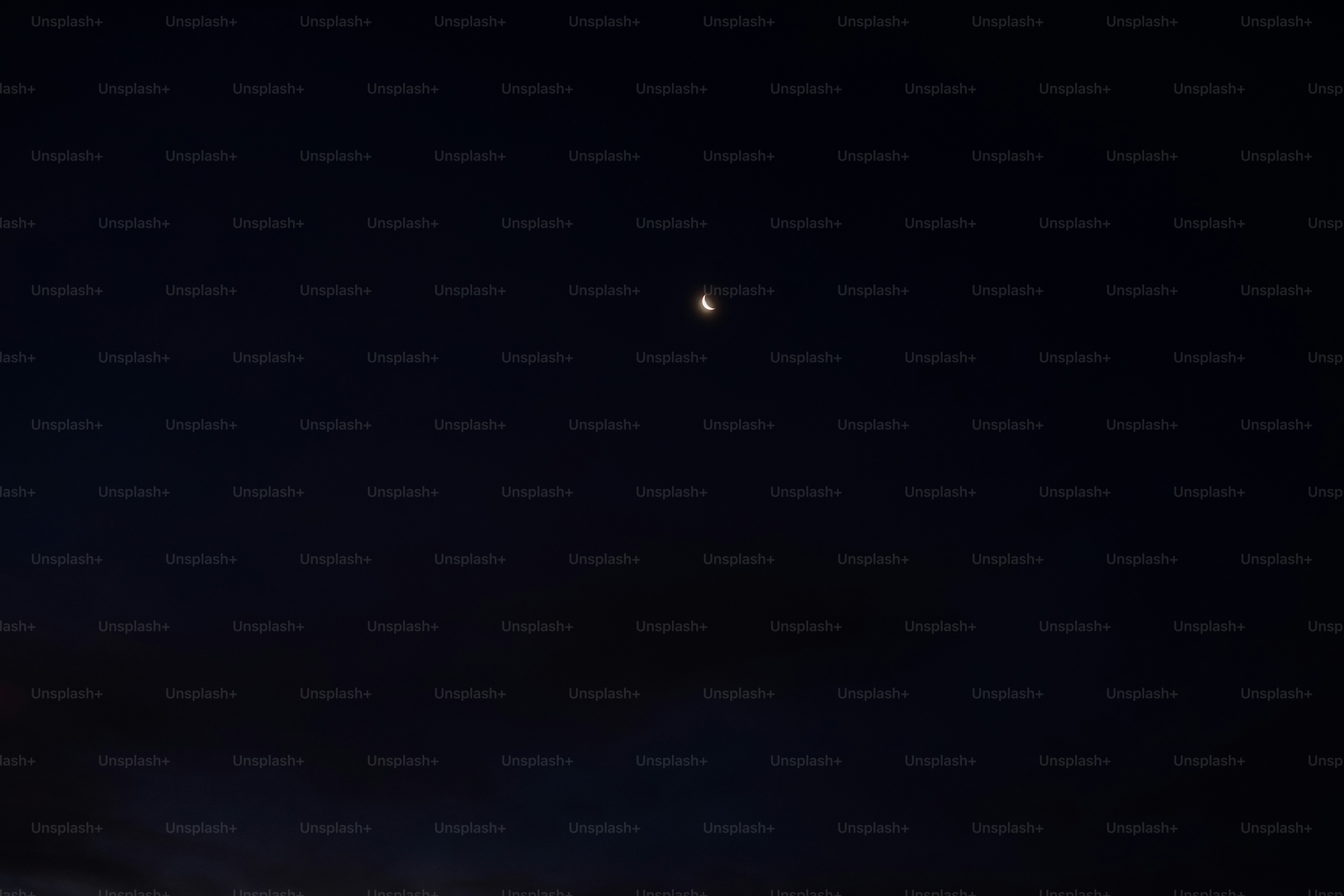 A full moon is seen in the dark sky