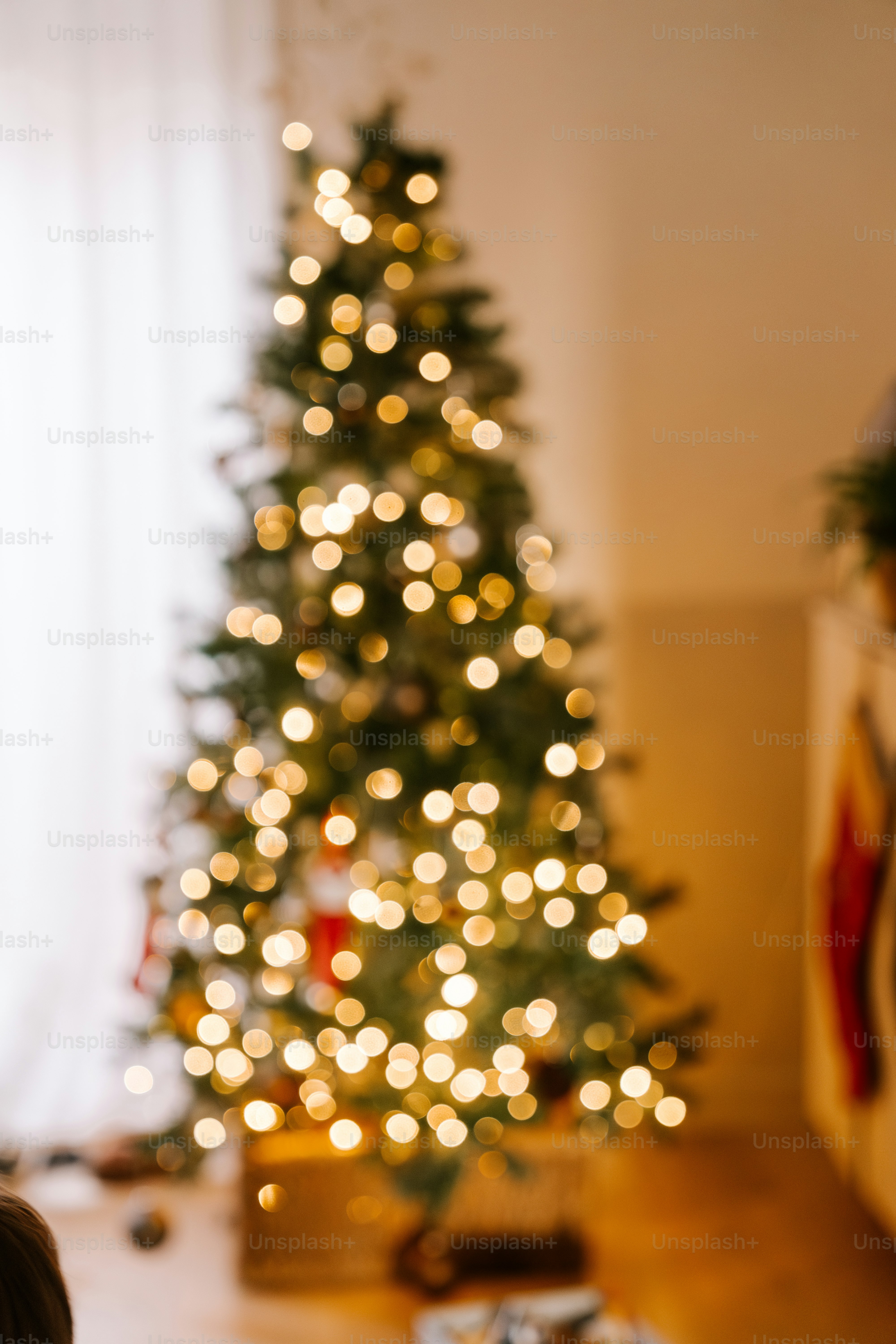 A small child sitting in front of a christmas tree