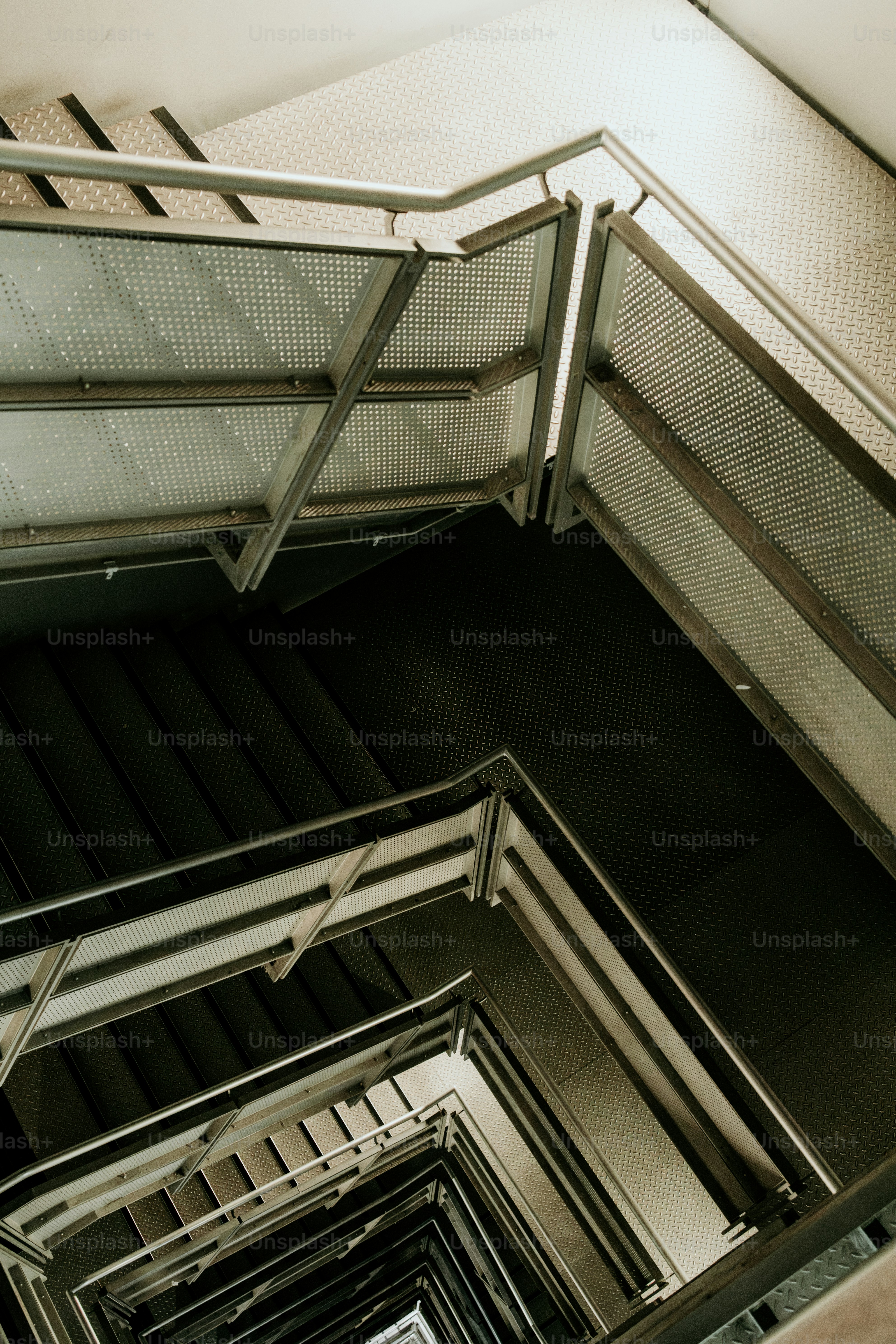 A stairwell with a metal handrail and railings