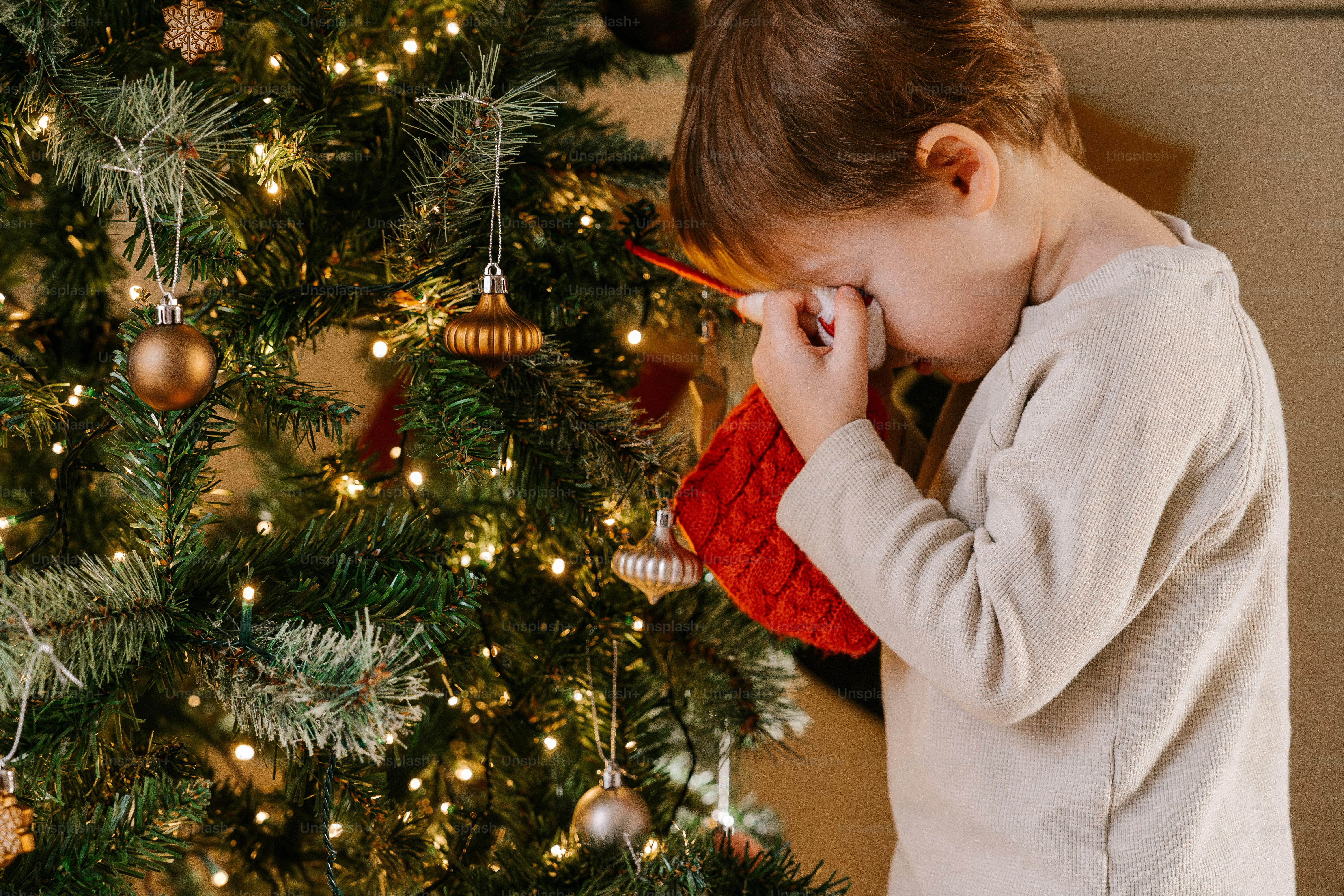 A little girl standing in front of a christmas tree