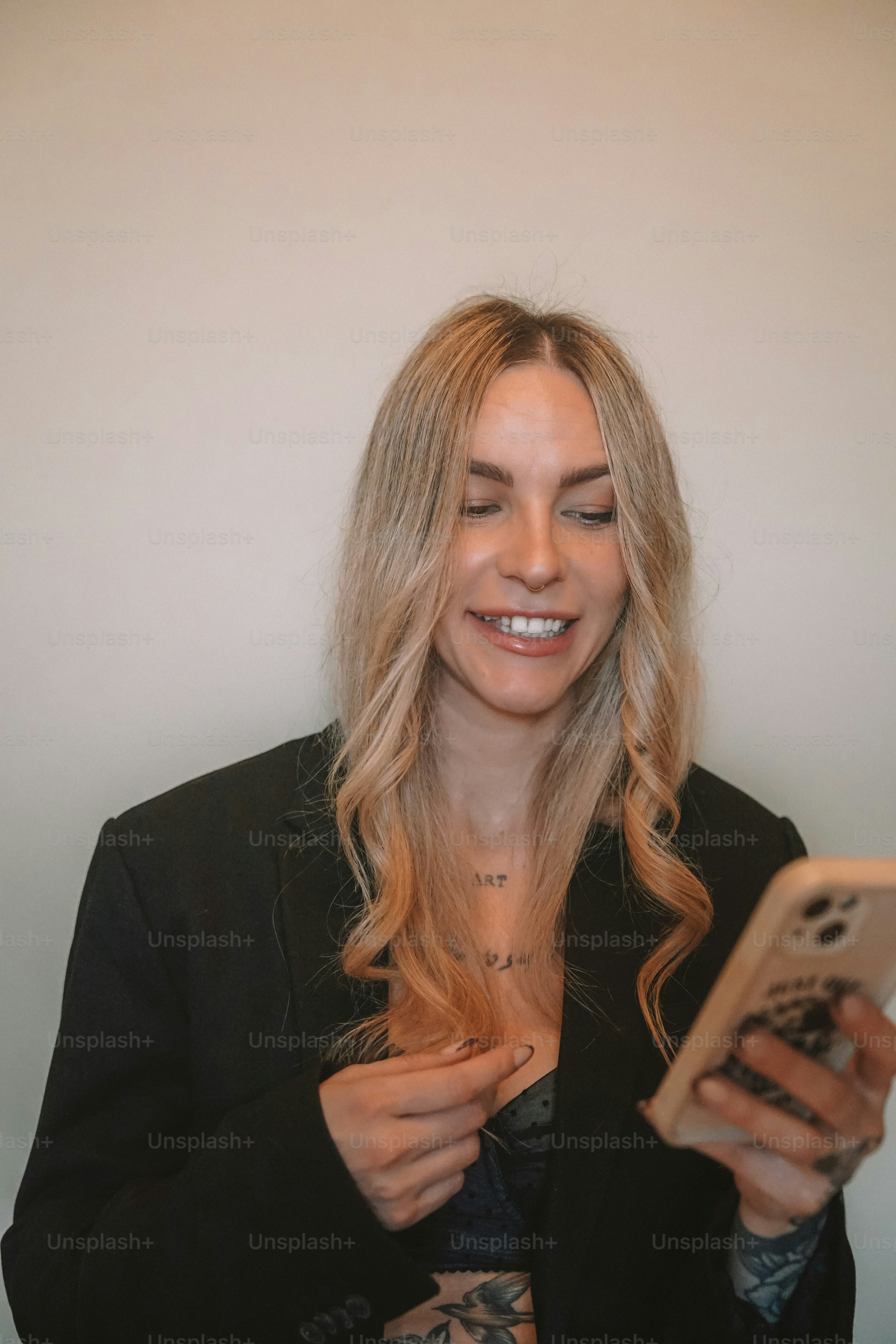A woman smiles while looking at her cell phone
