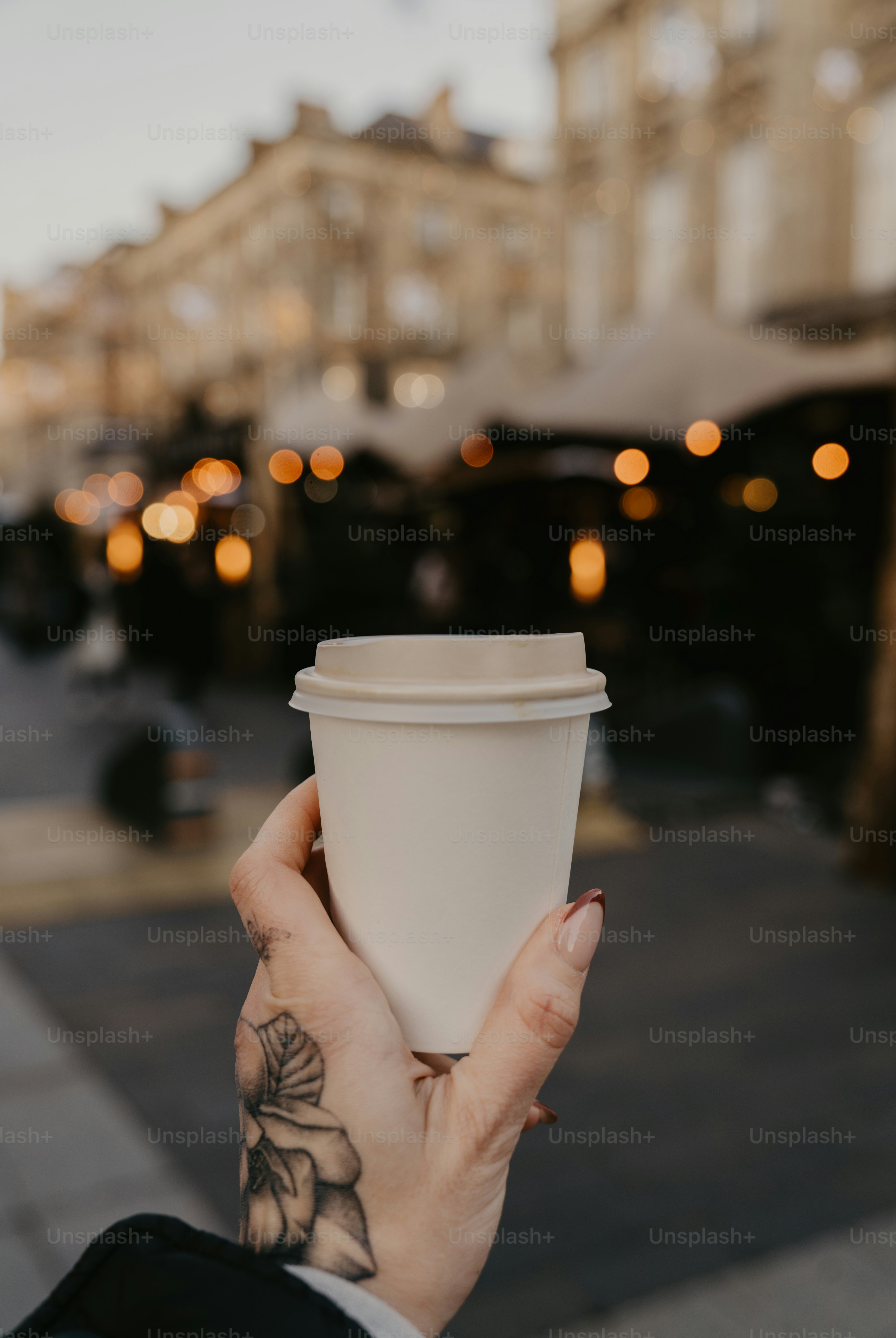 A person holding a cup of coffee in their hand