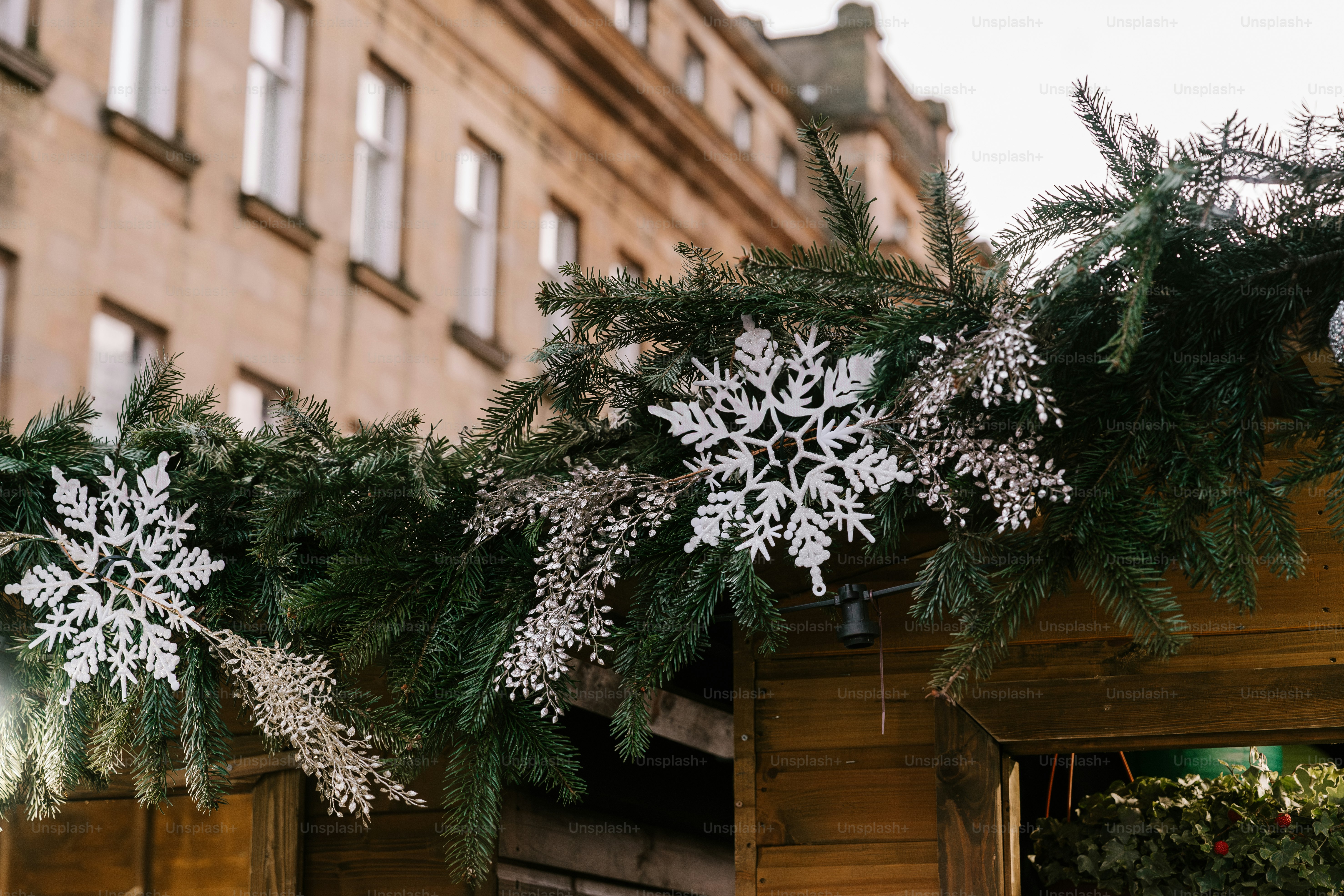 Snowflakes are hanging from the roof of a building