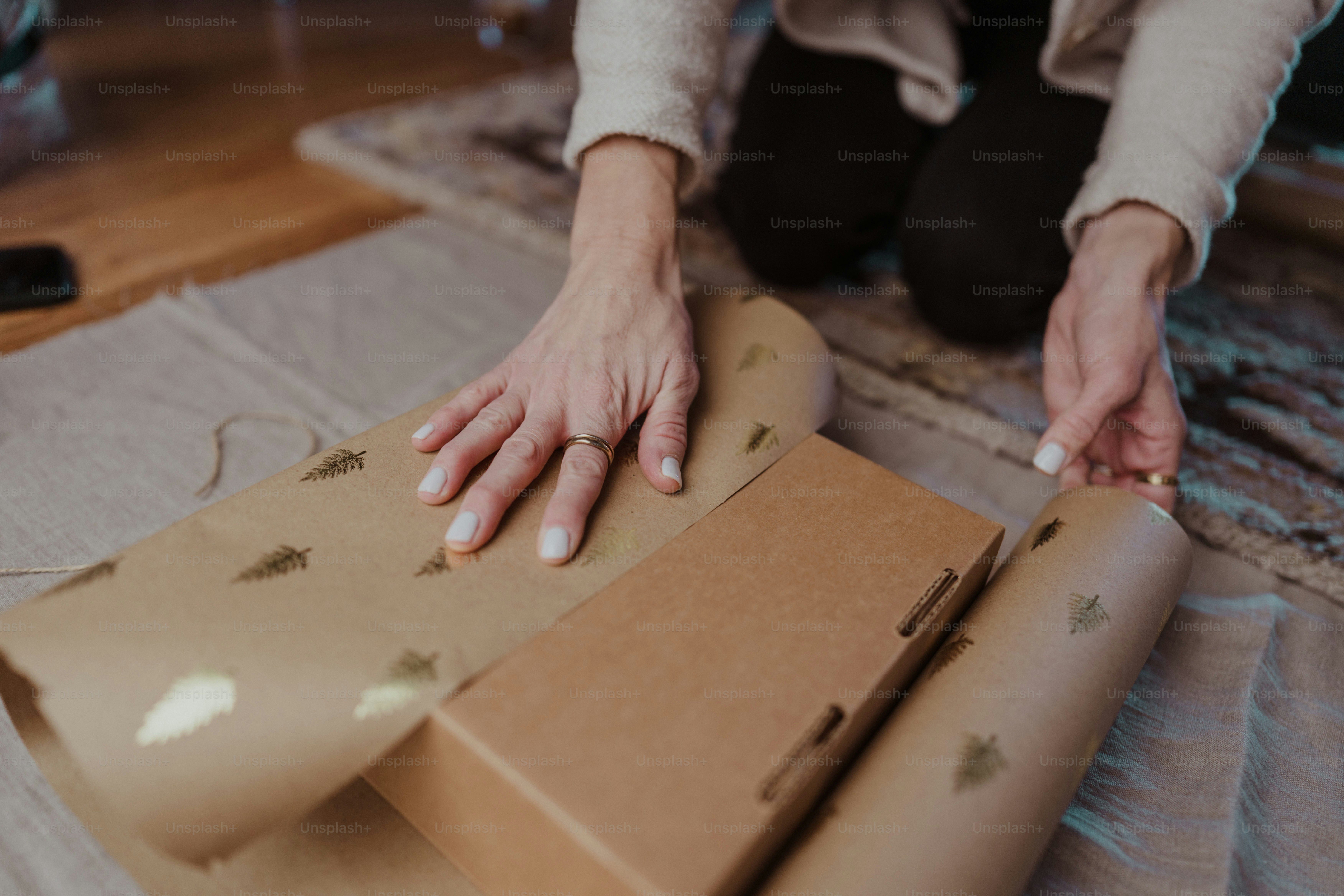 A woman is wrapping a box on the floor