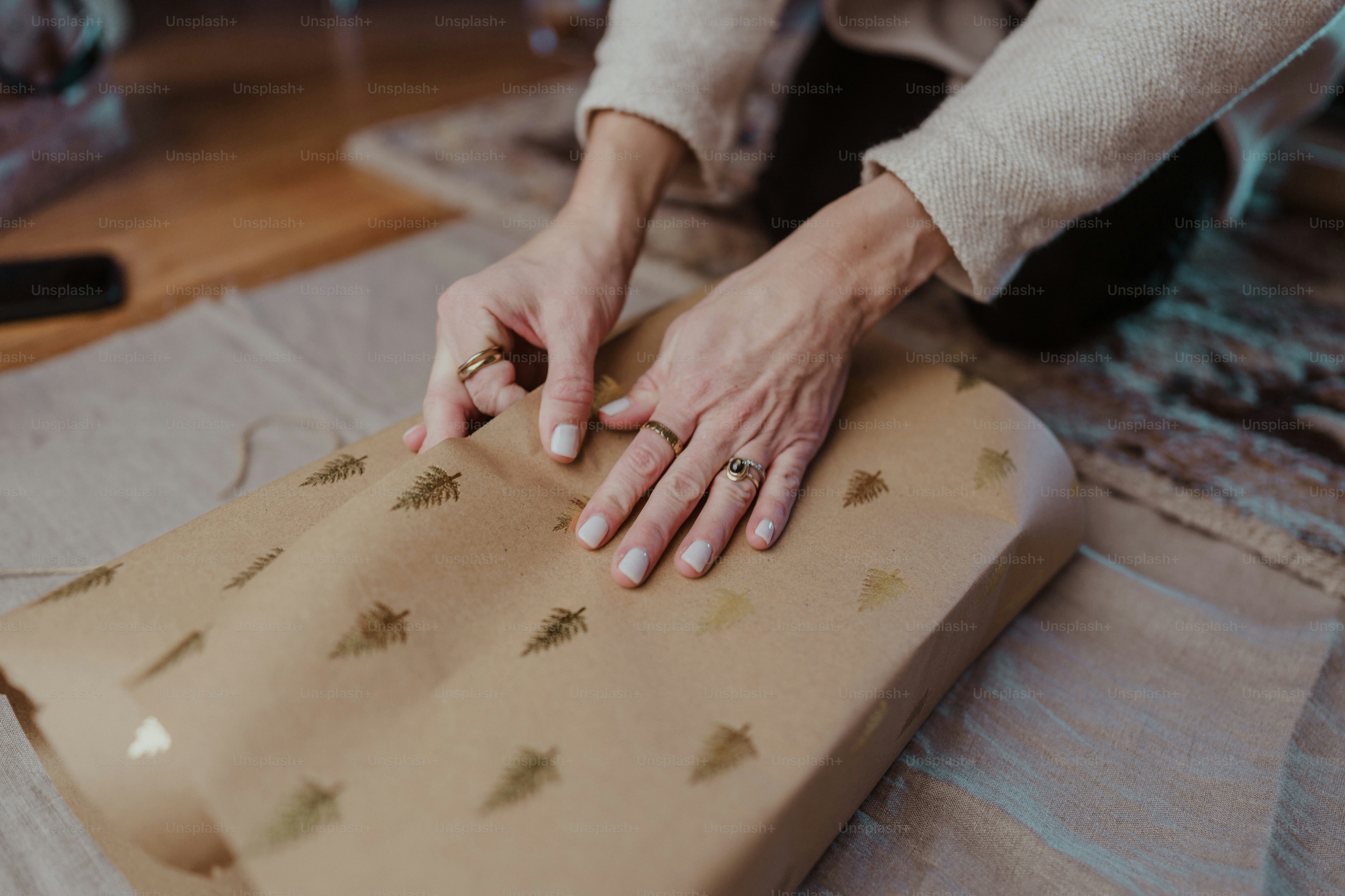 A person wrapping a present on the floor