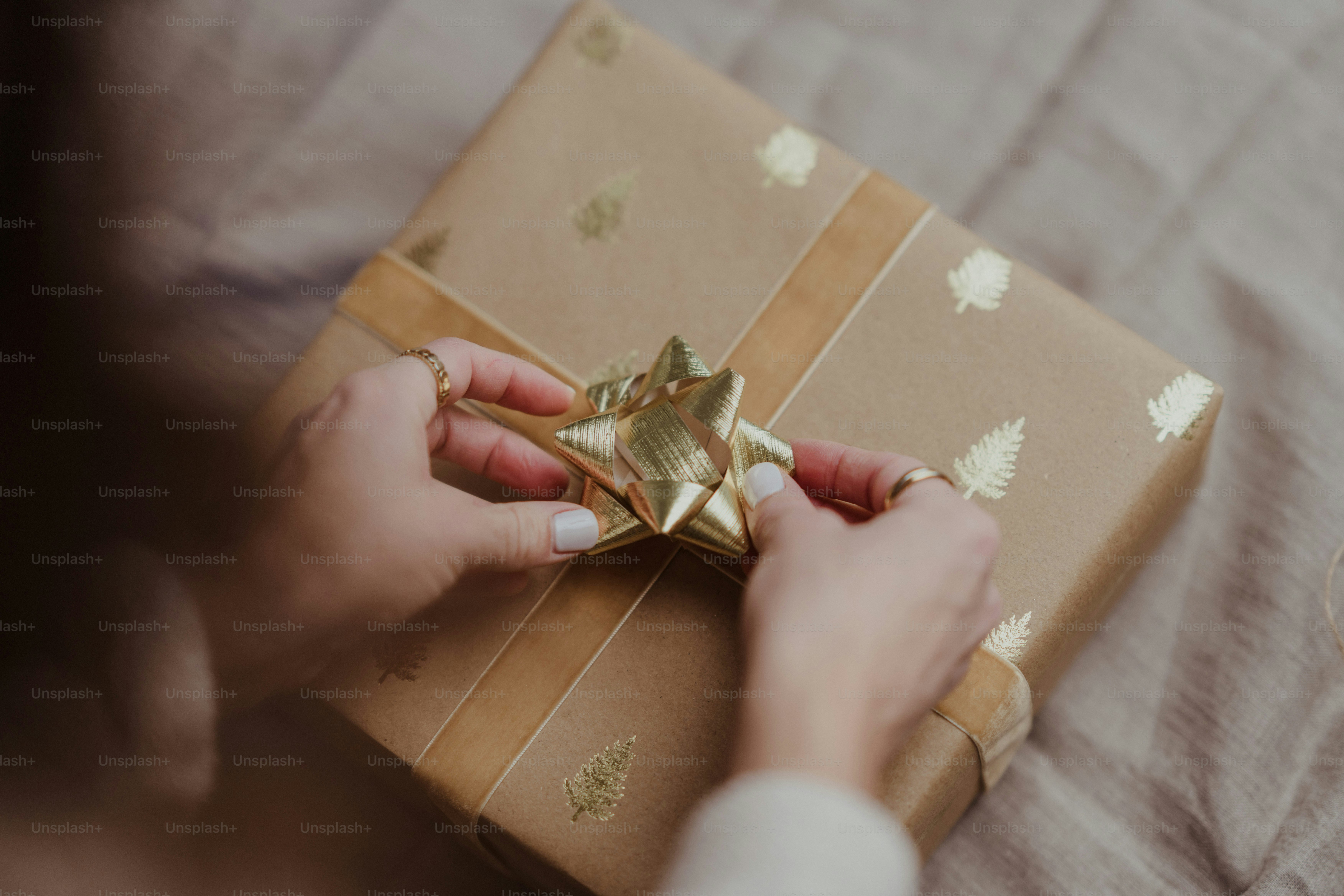 A woman holding a wrapped gift box on a bed