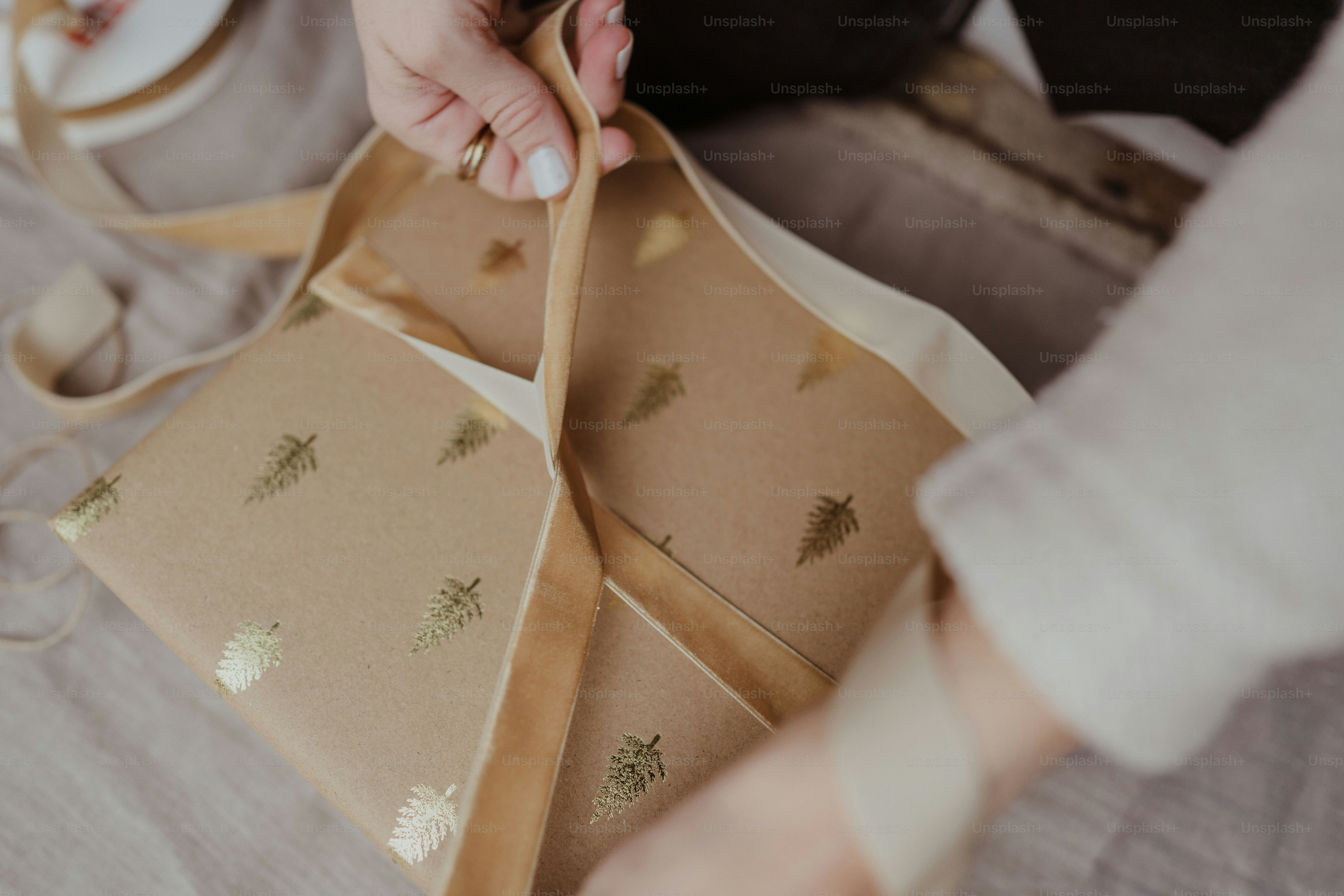 A woman is wrapping a gift in brown paper