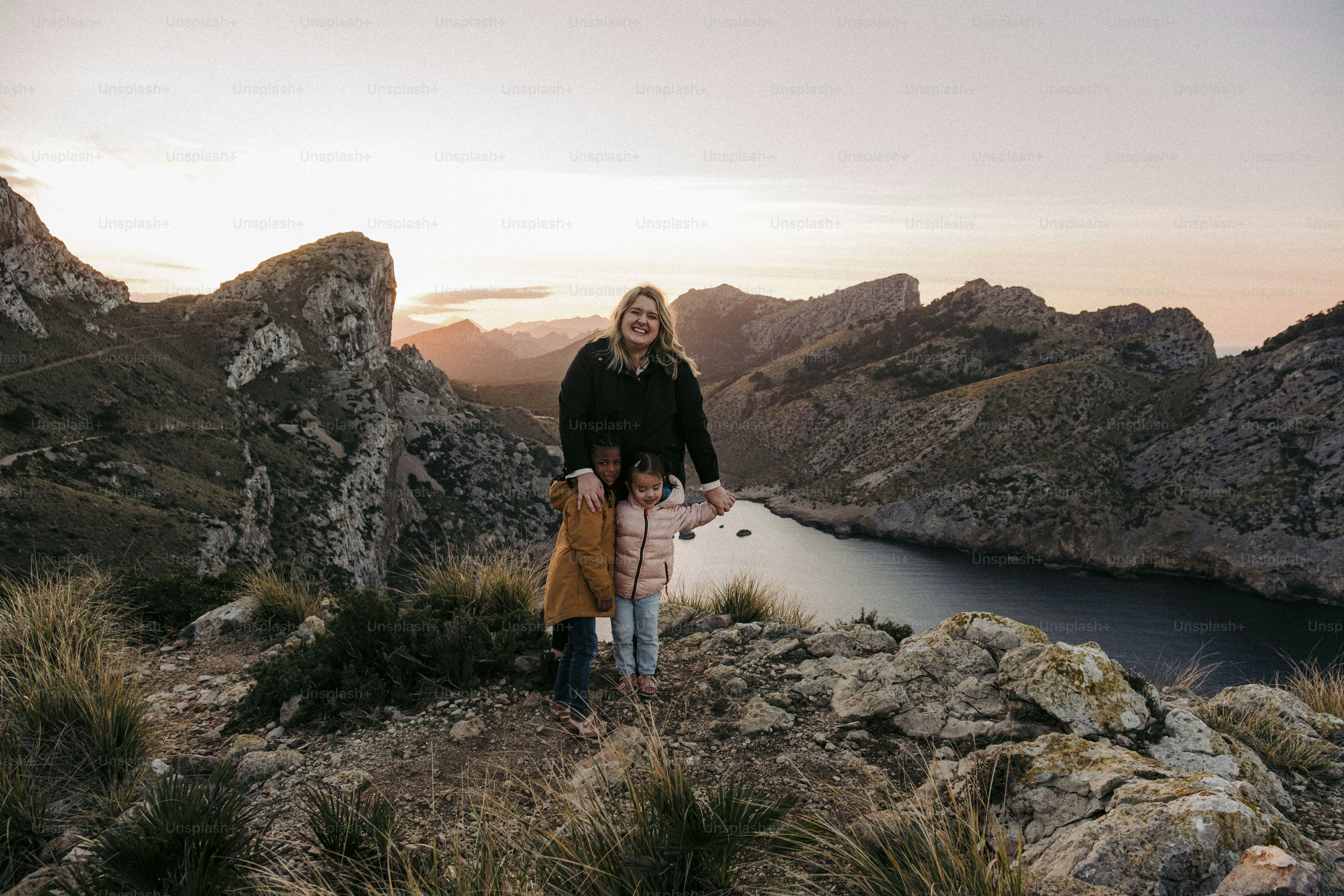 A woman and a child standing on a mountain