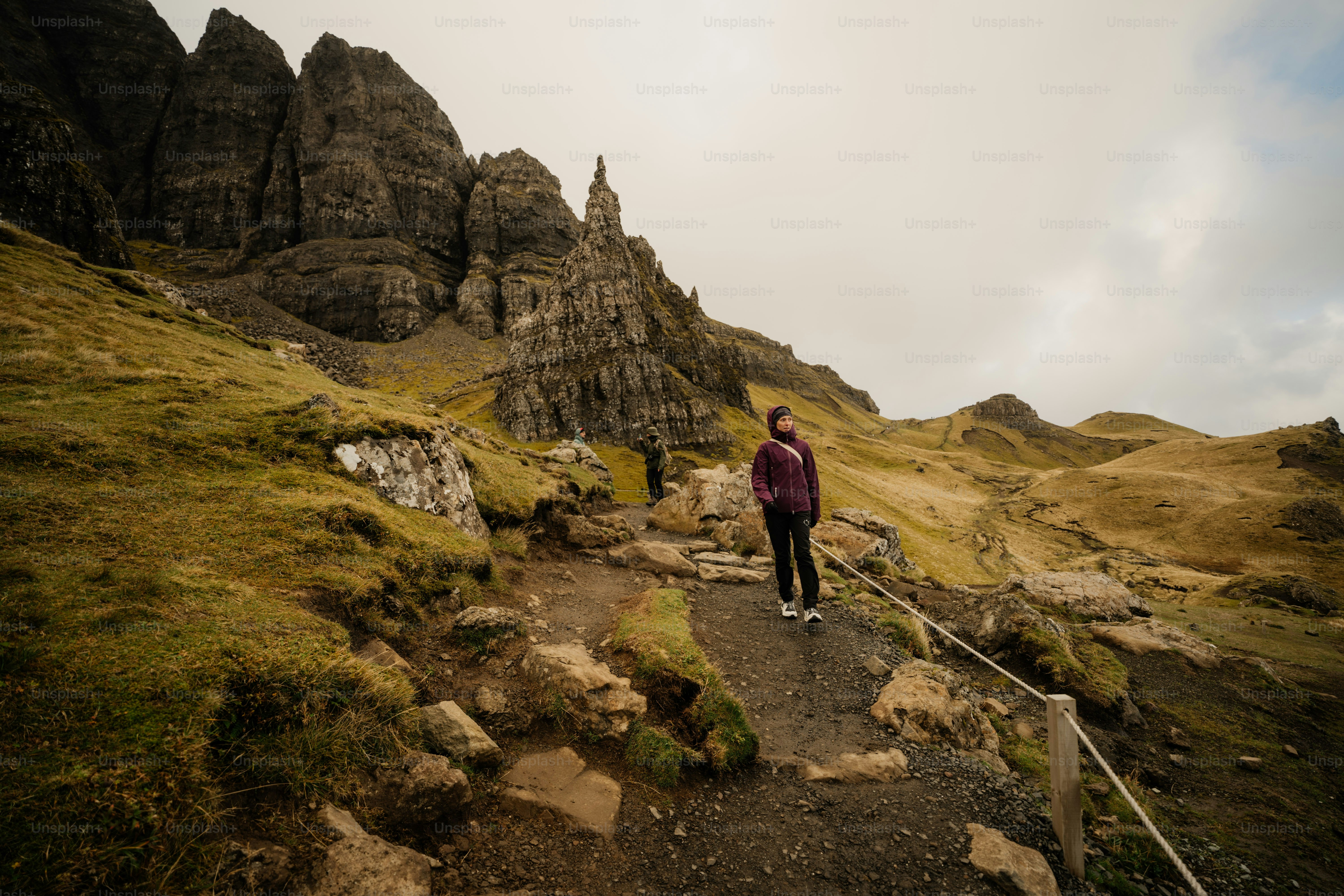 A man standing on a path in the mountains