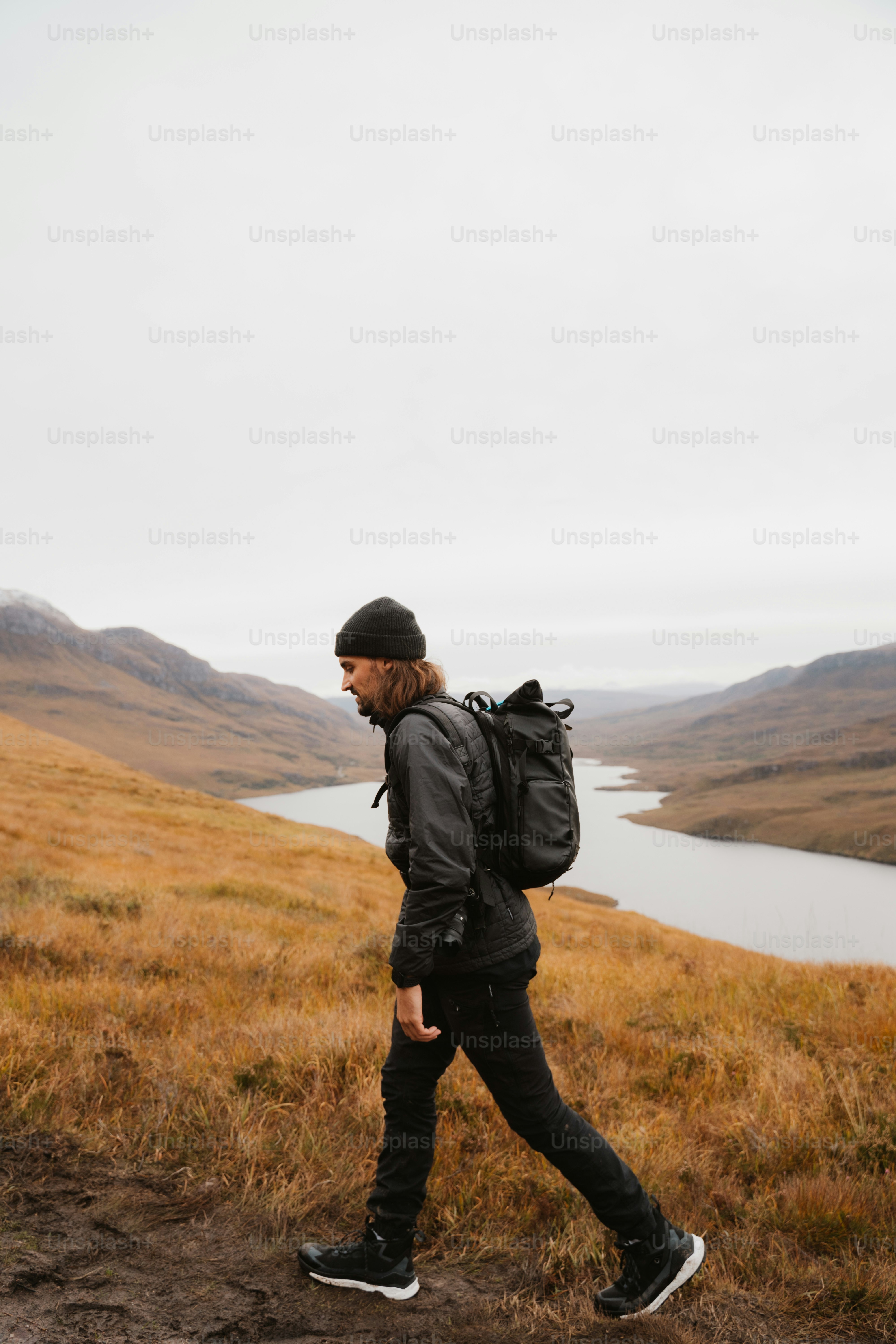 A man with a backpack walking up a hill