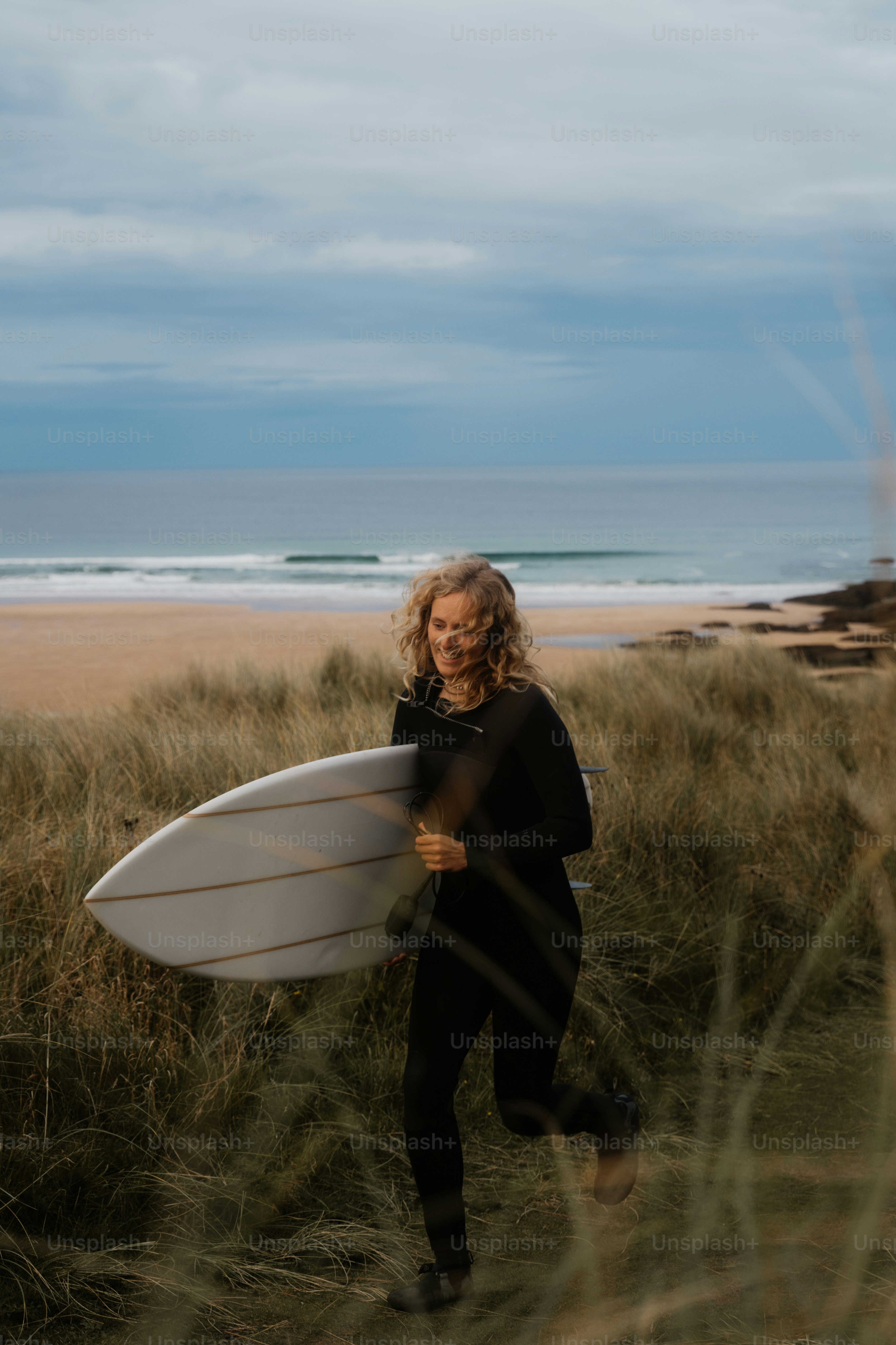 A woman holding a surfboard on a beach