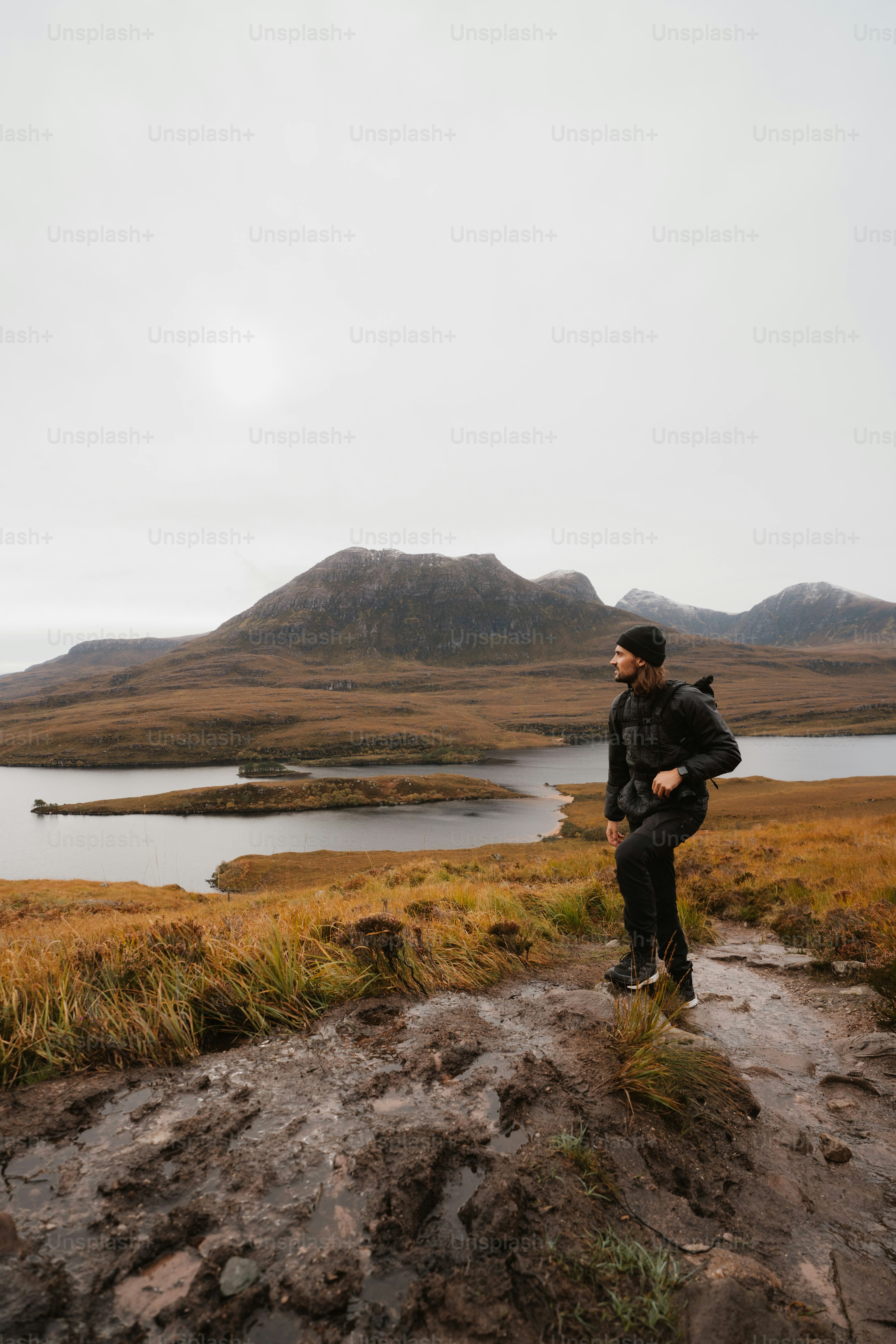 A man standing on top of a hill next to a lake
