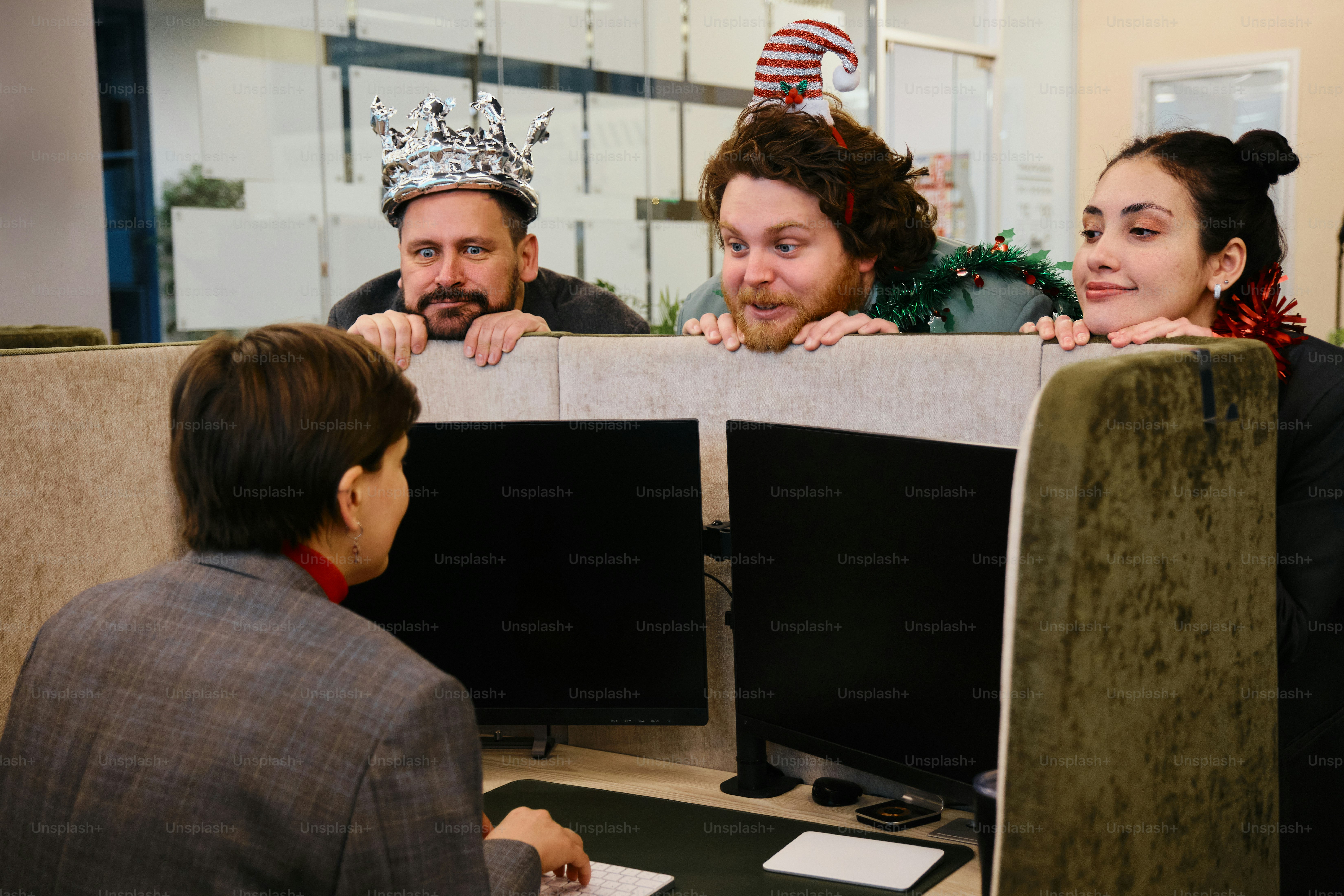 Un grupo de personas sentadas frente a monitores de computadora