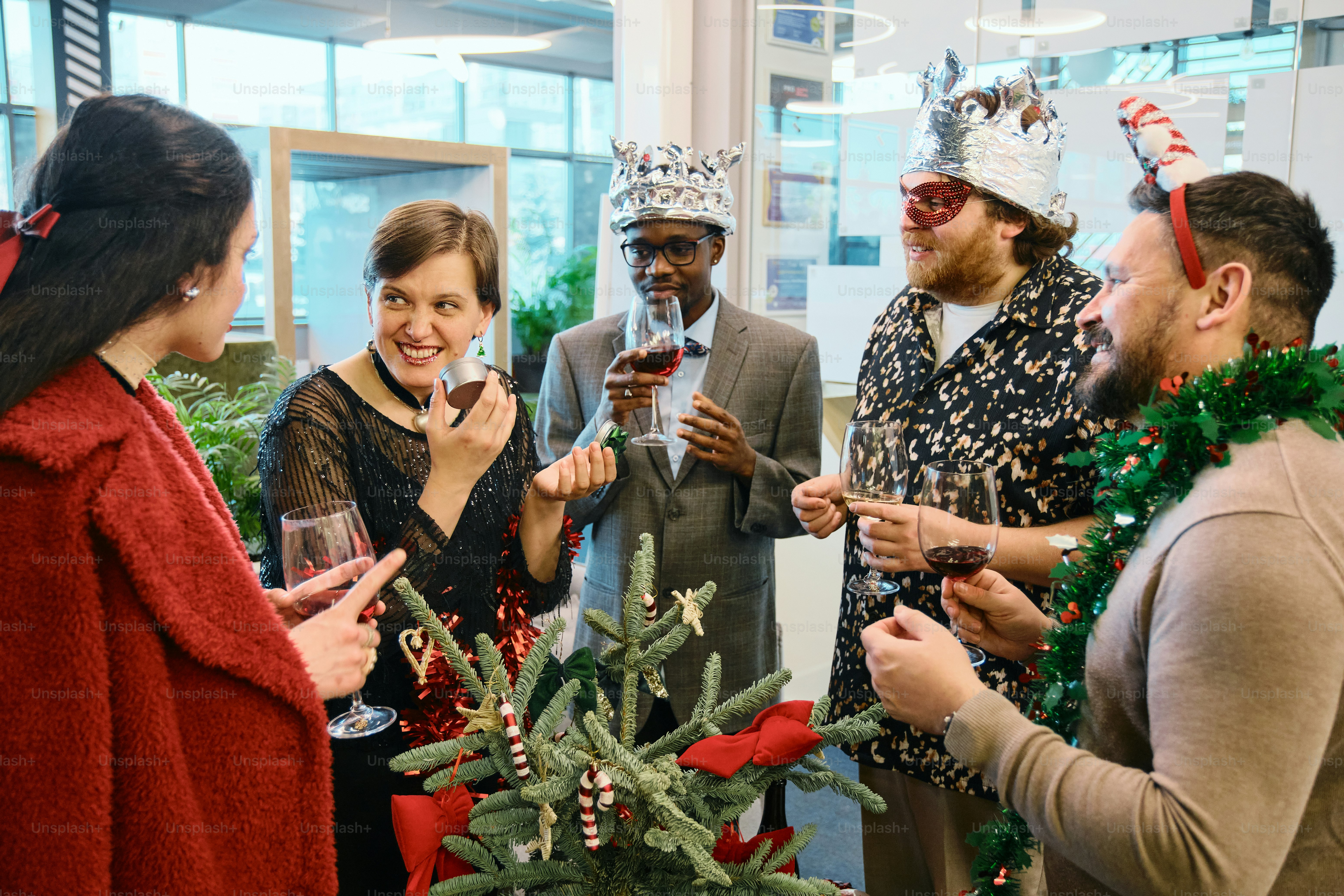 A group of people standing around a christmas tree