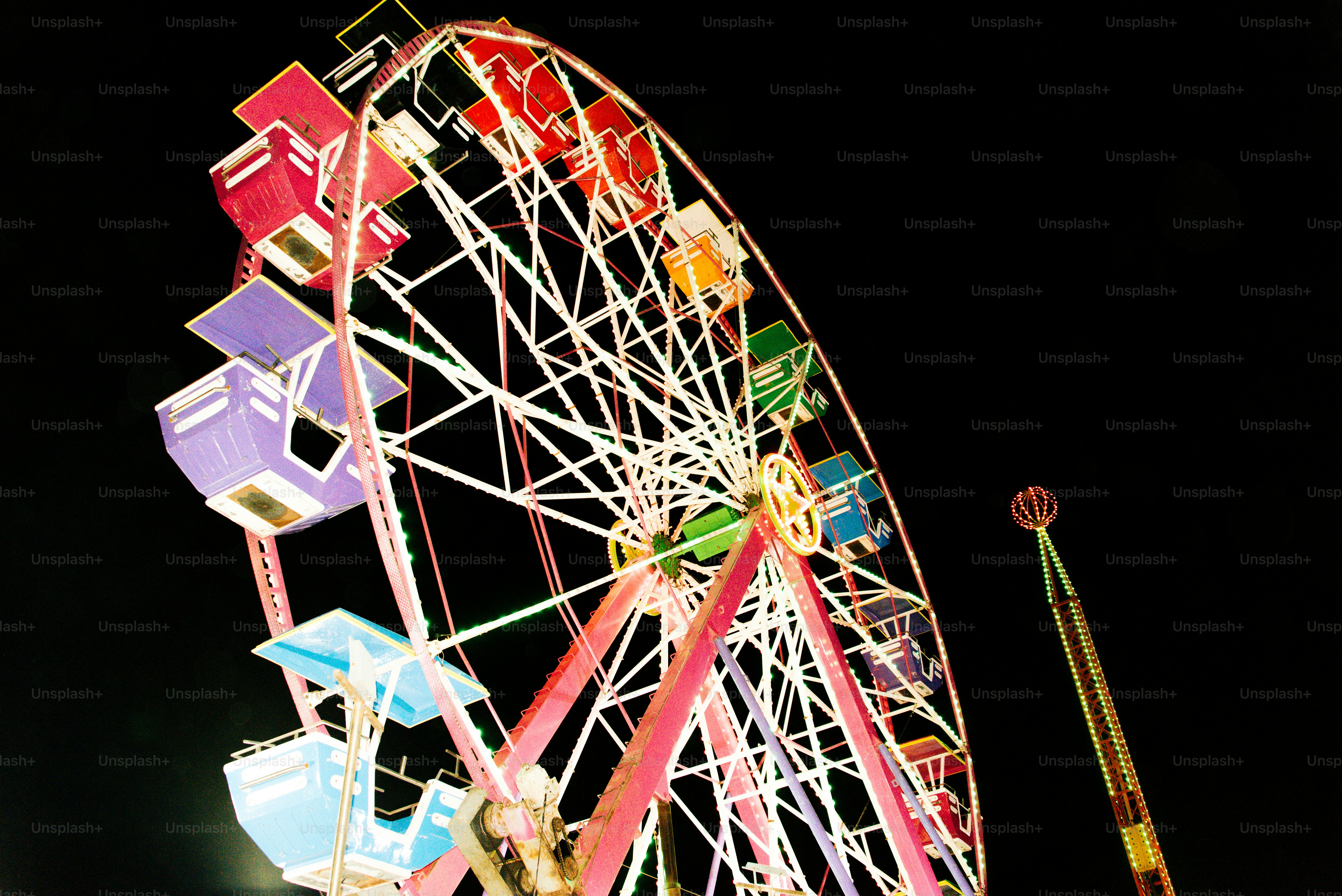 A ferris wheel is lit up at night