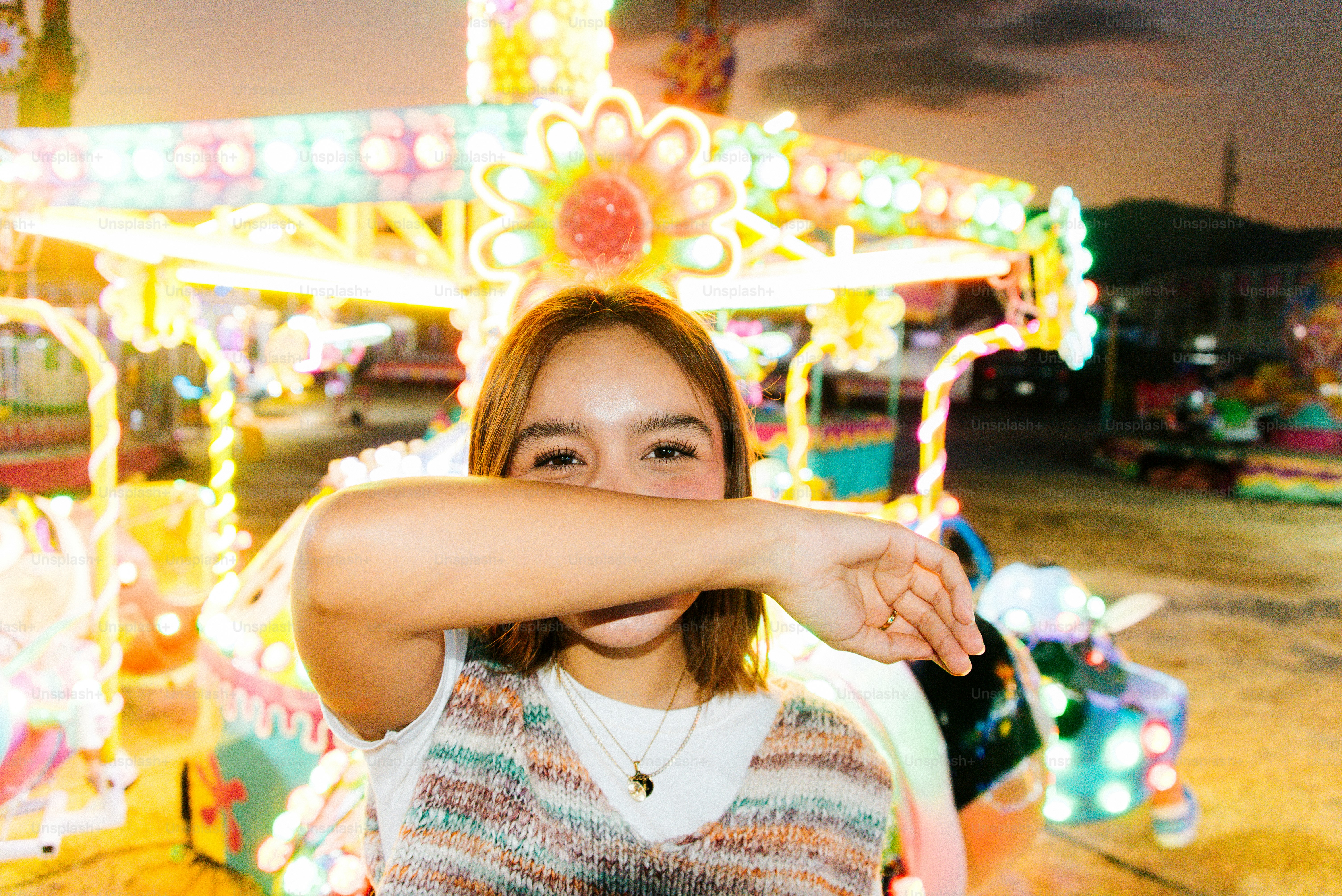 A woman standing in front of a carnival ride
