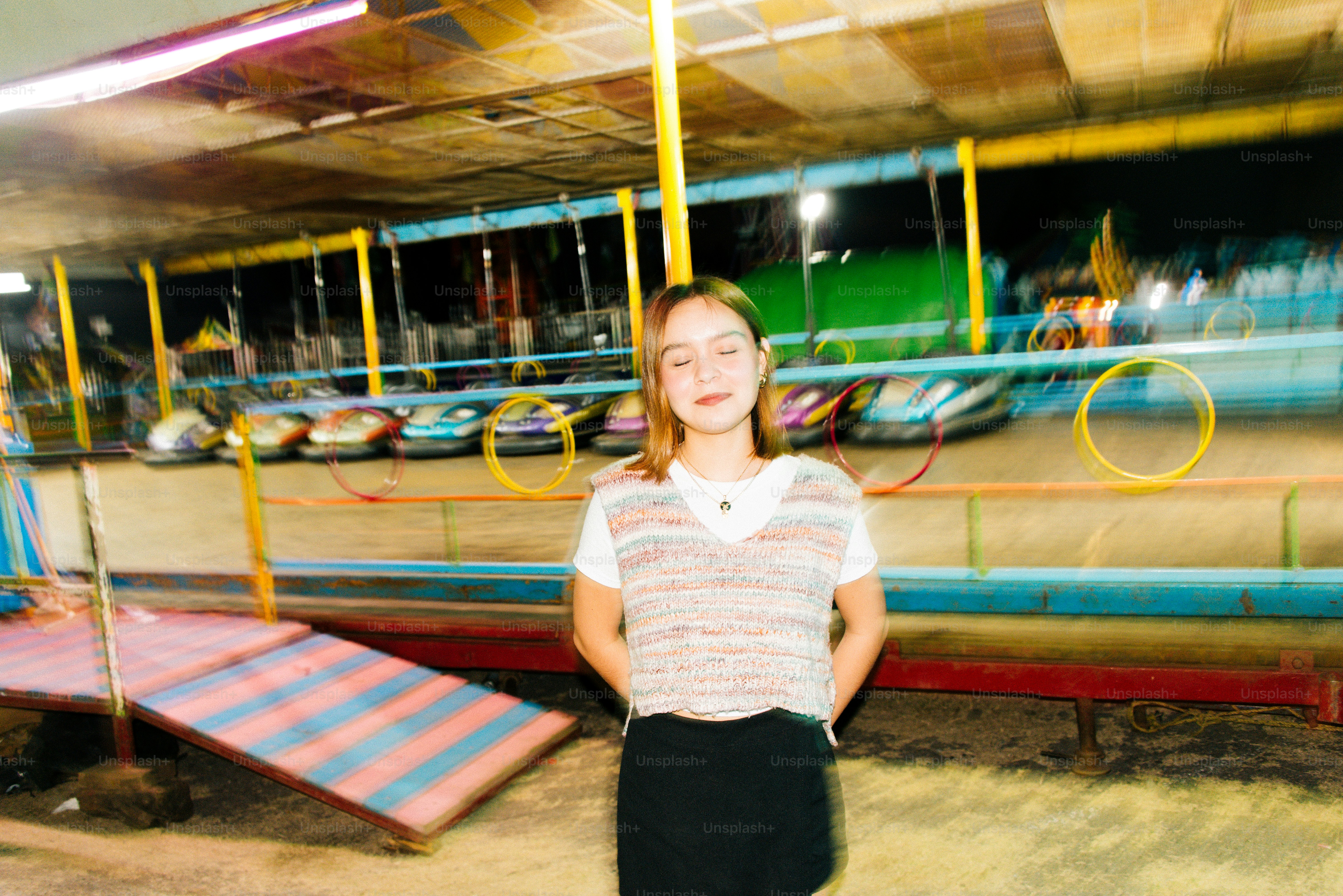 A woman standing in front of a carnival ride
