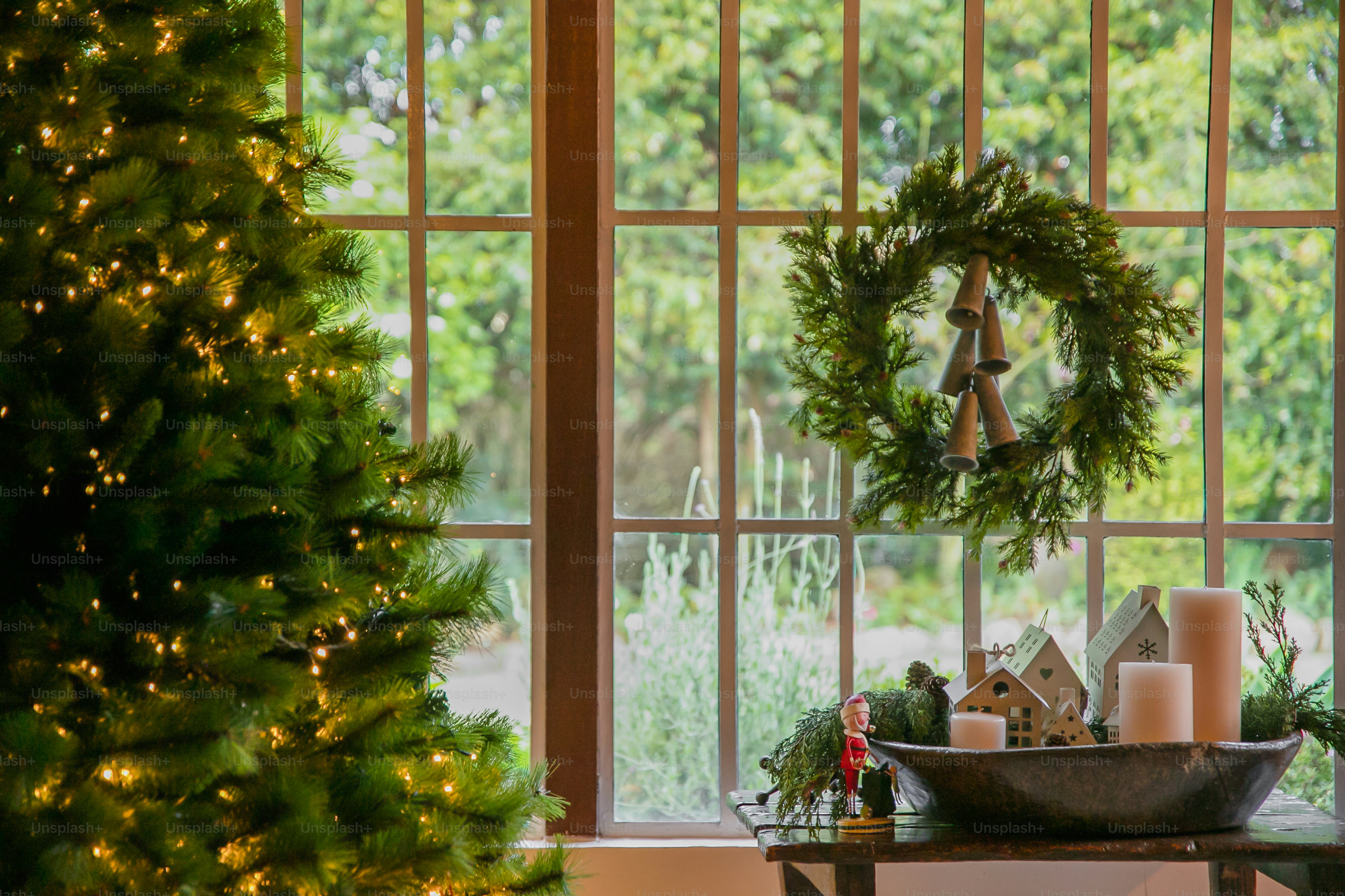 A living room with a christmas tree and a window