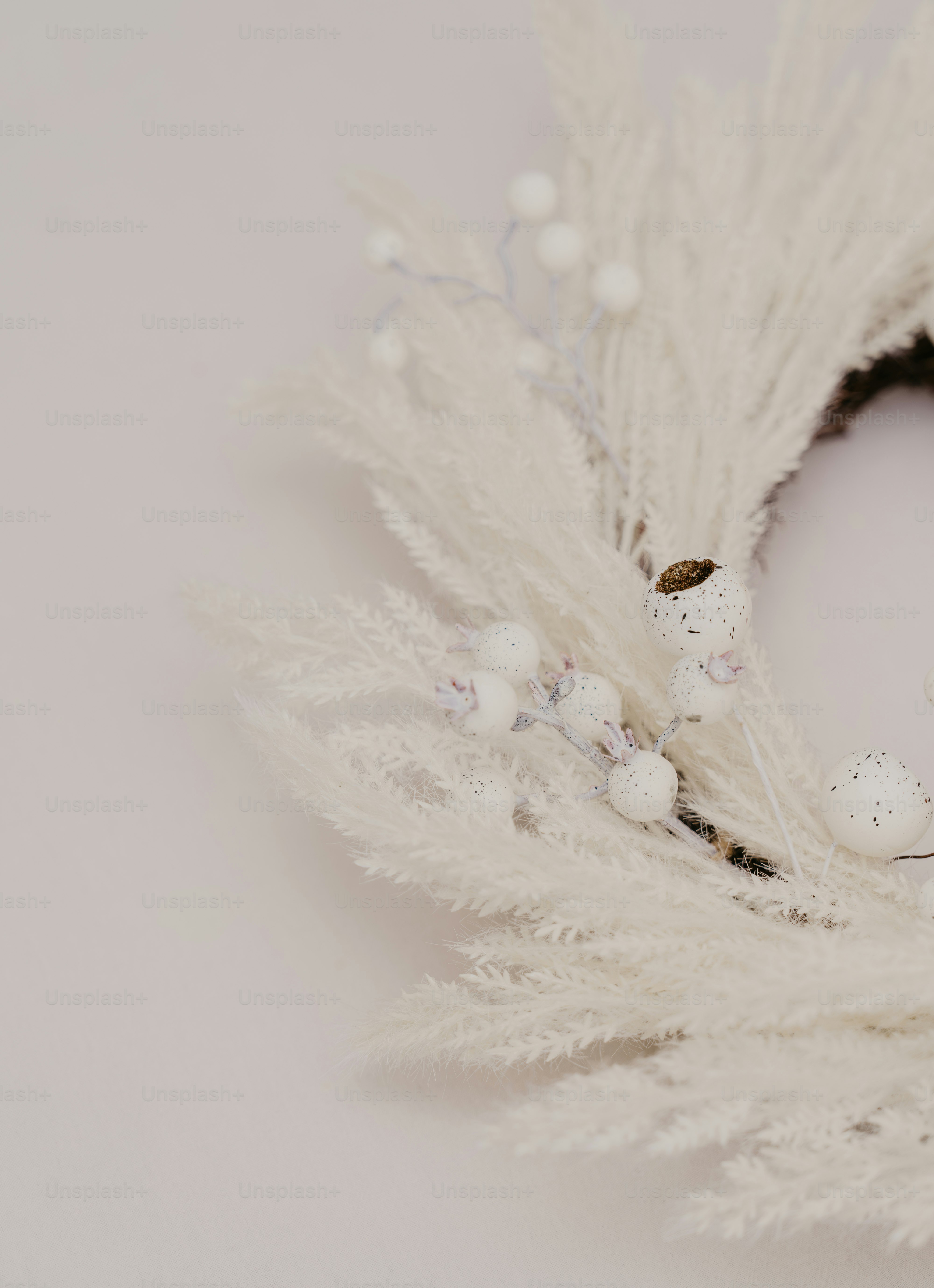 A close up of a wreath with white feathers