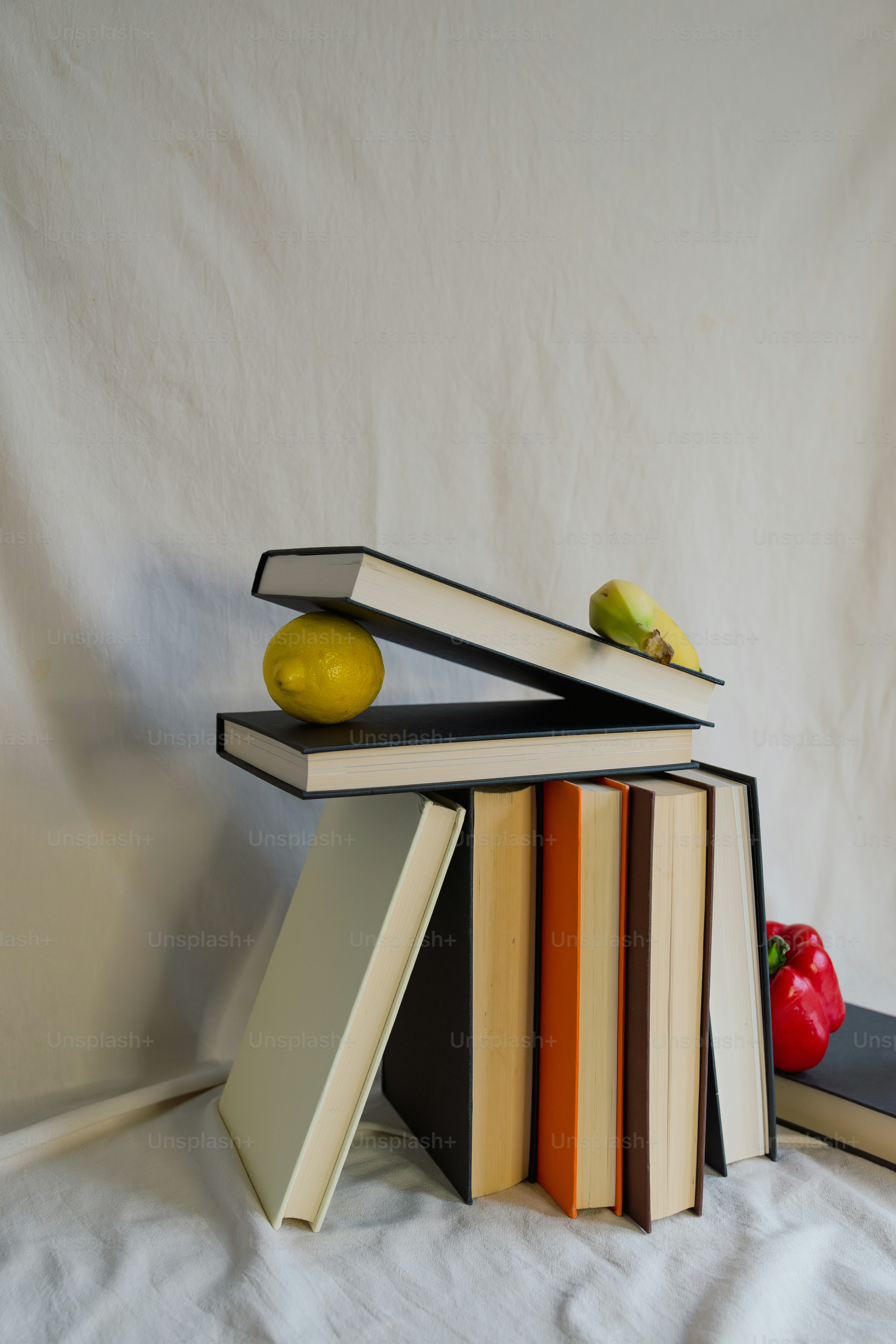 A stack of books sitting on top of a bed