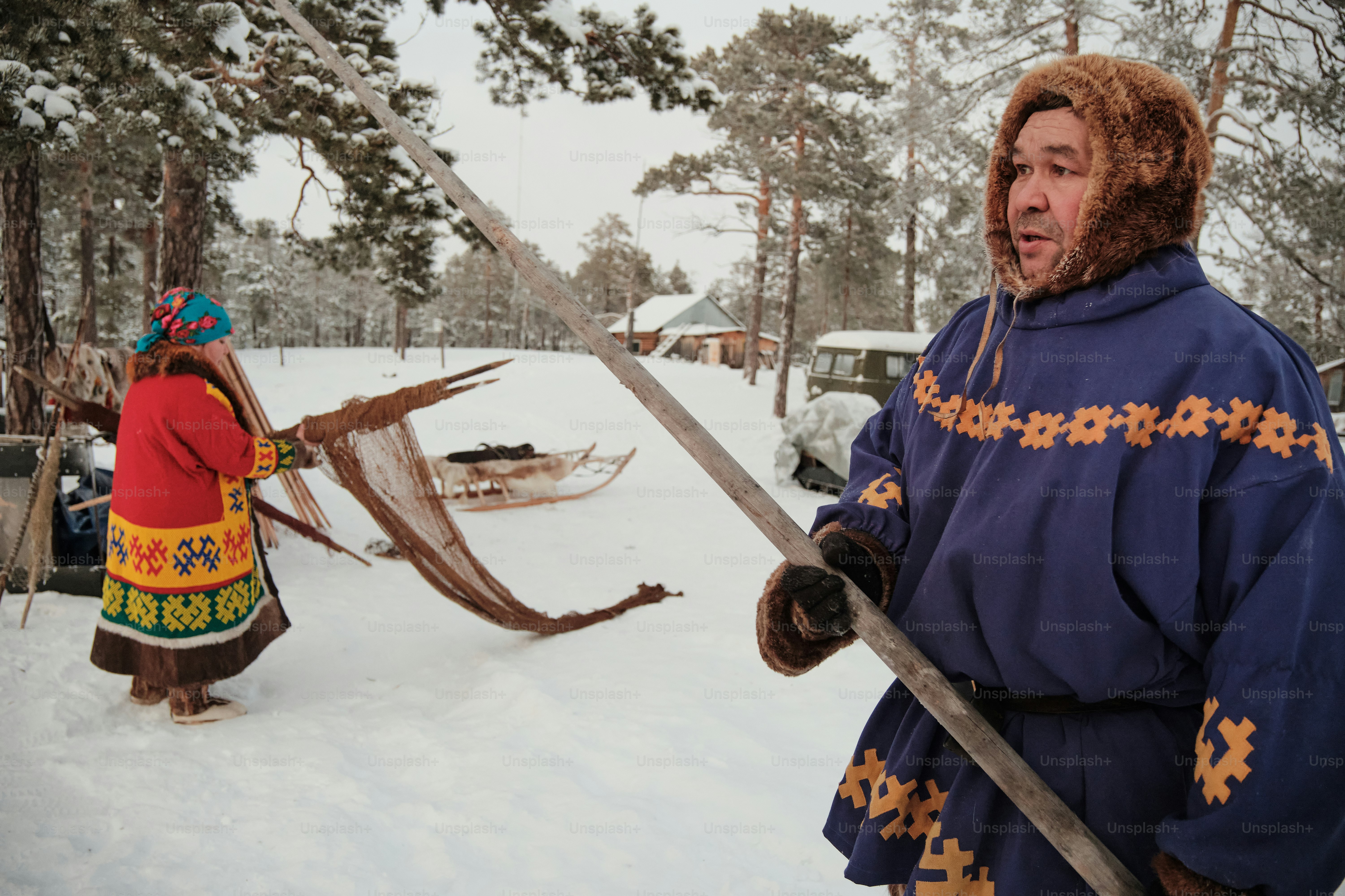 A man in a native american outfit standing in the snow