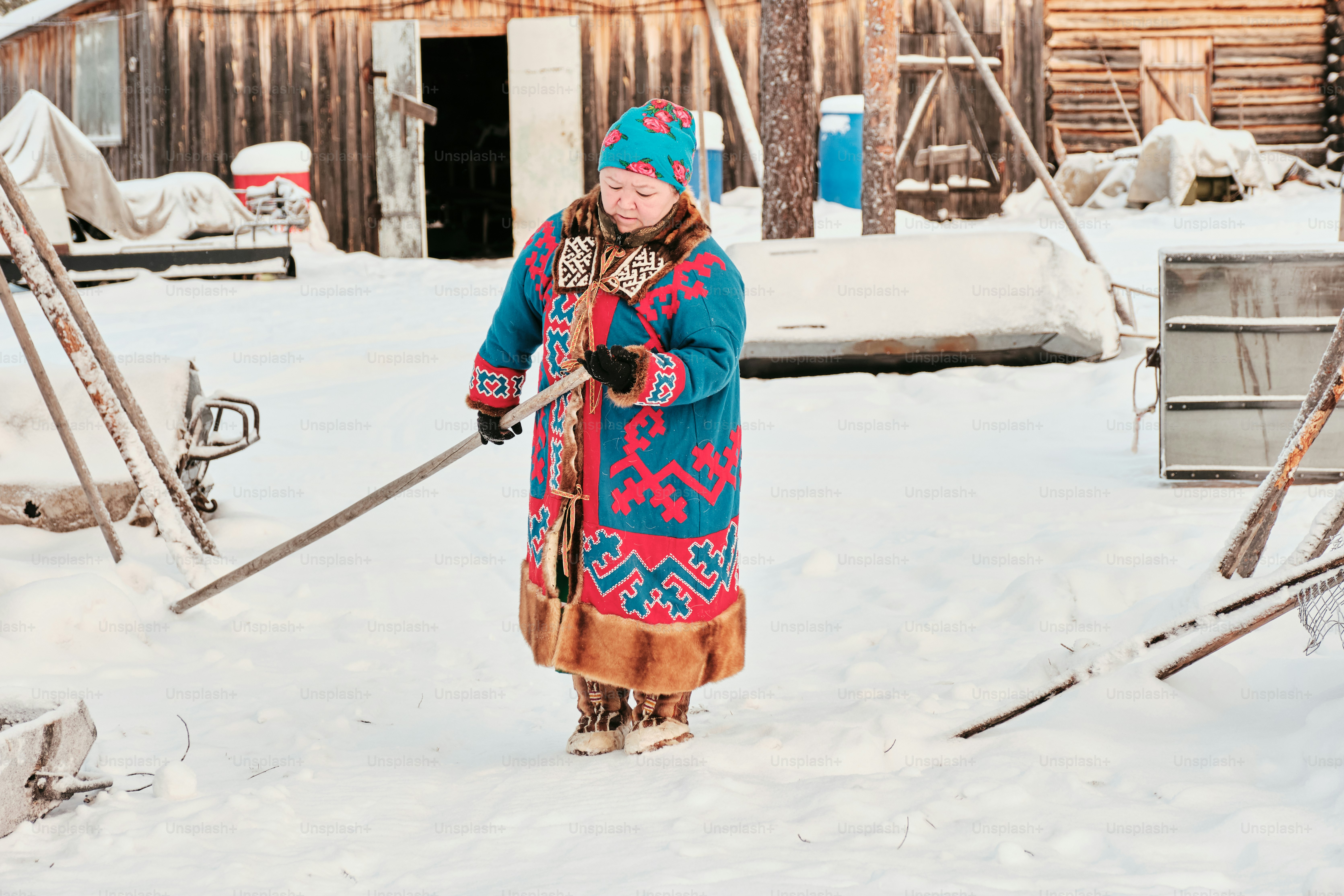 A woman walking through the snow with skis