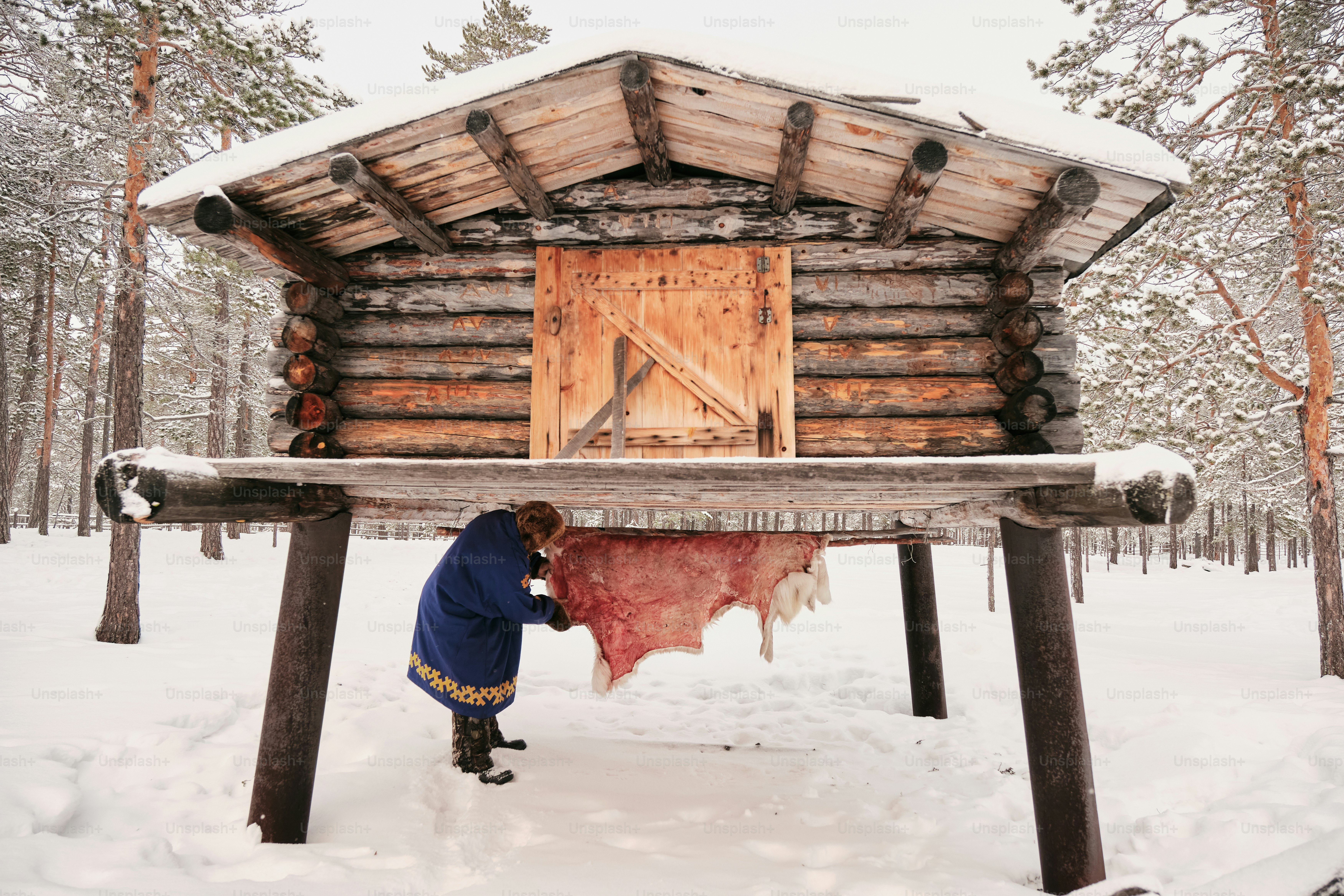 A man is bending over to pick up something from the snow