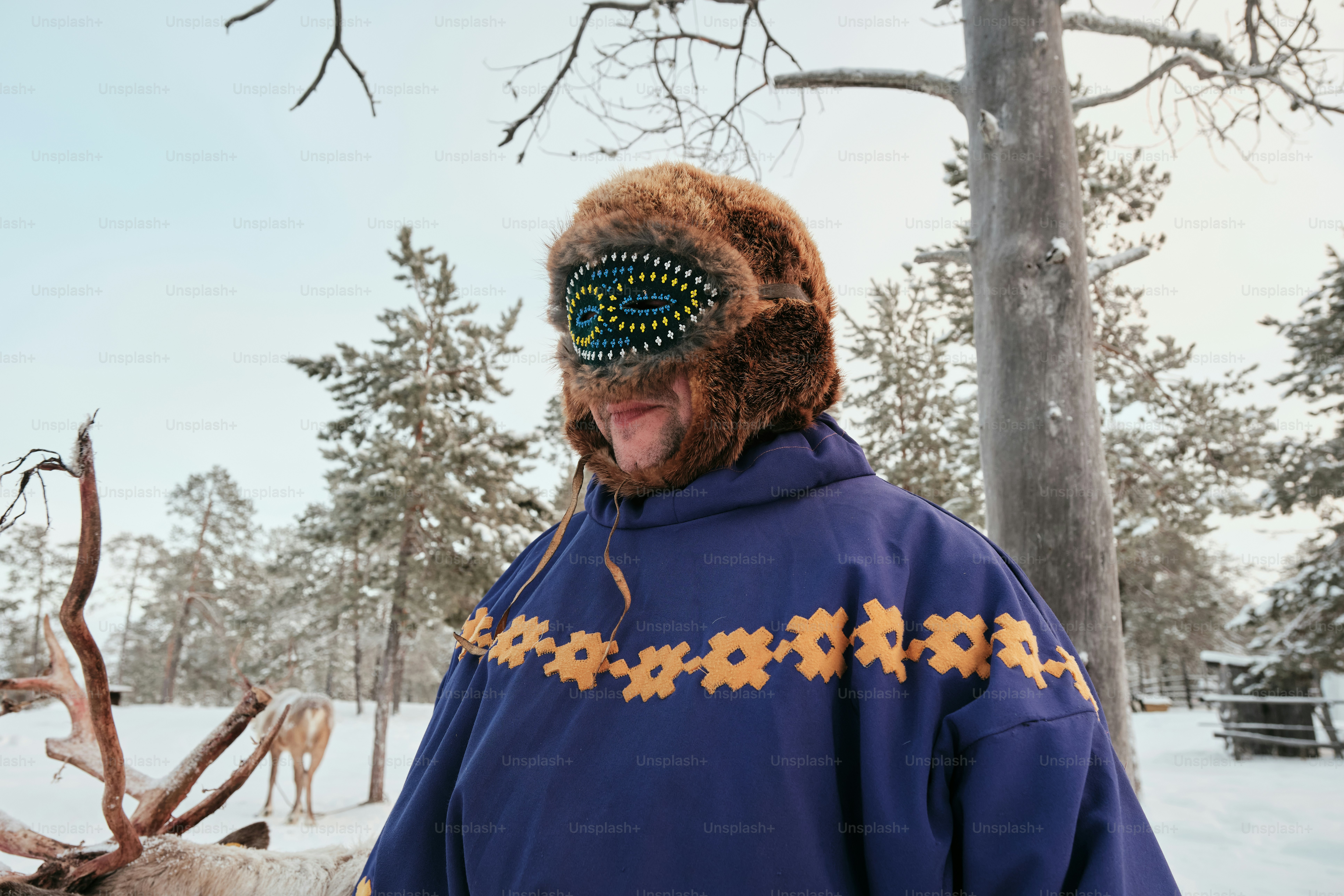A man in a blue jacket standing in the snow
